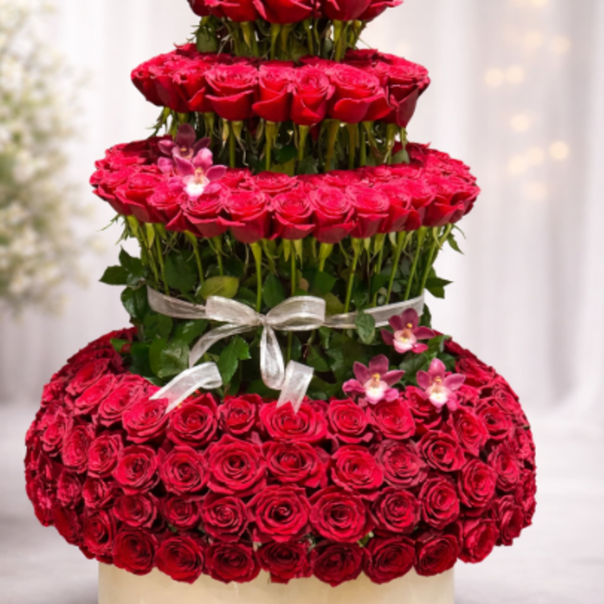 A multi-tiered tower of tightly clustered red roses makes a bold, romantic