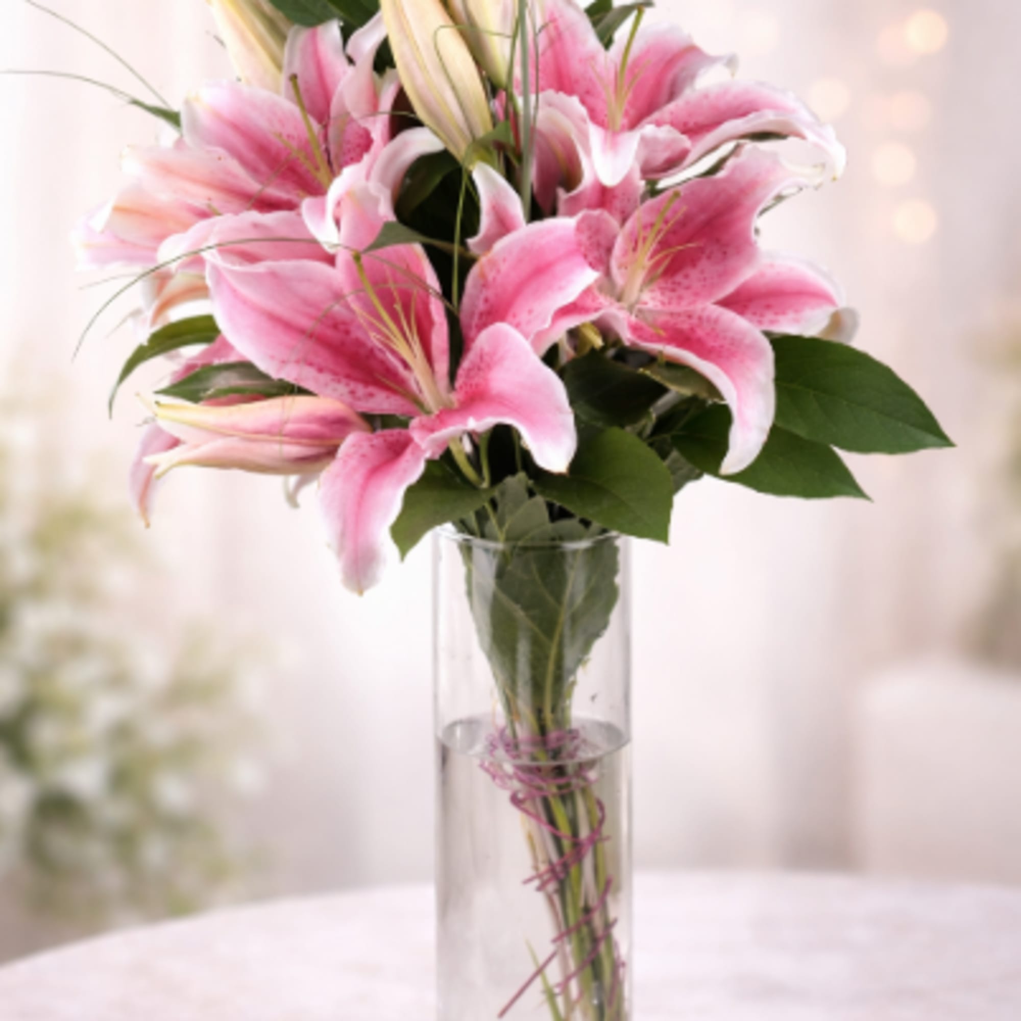 Vivid pink lilies with white-edged petals form a graceful, romantic centerpiece-perfect as