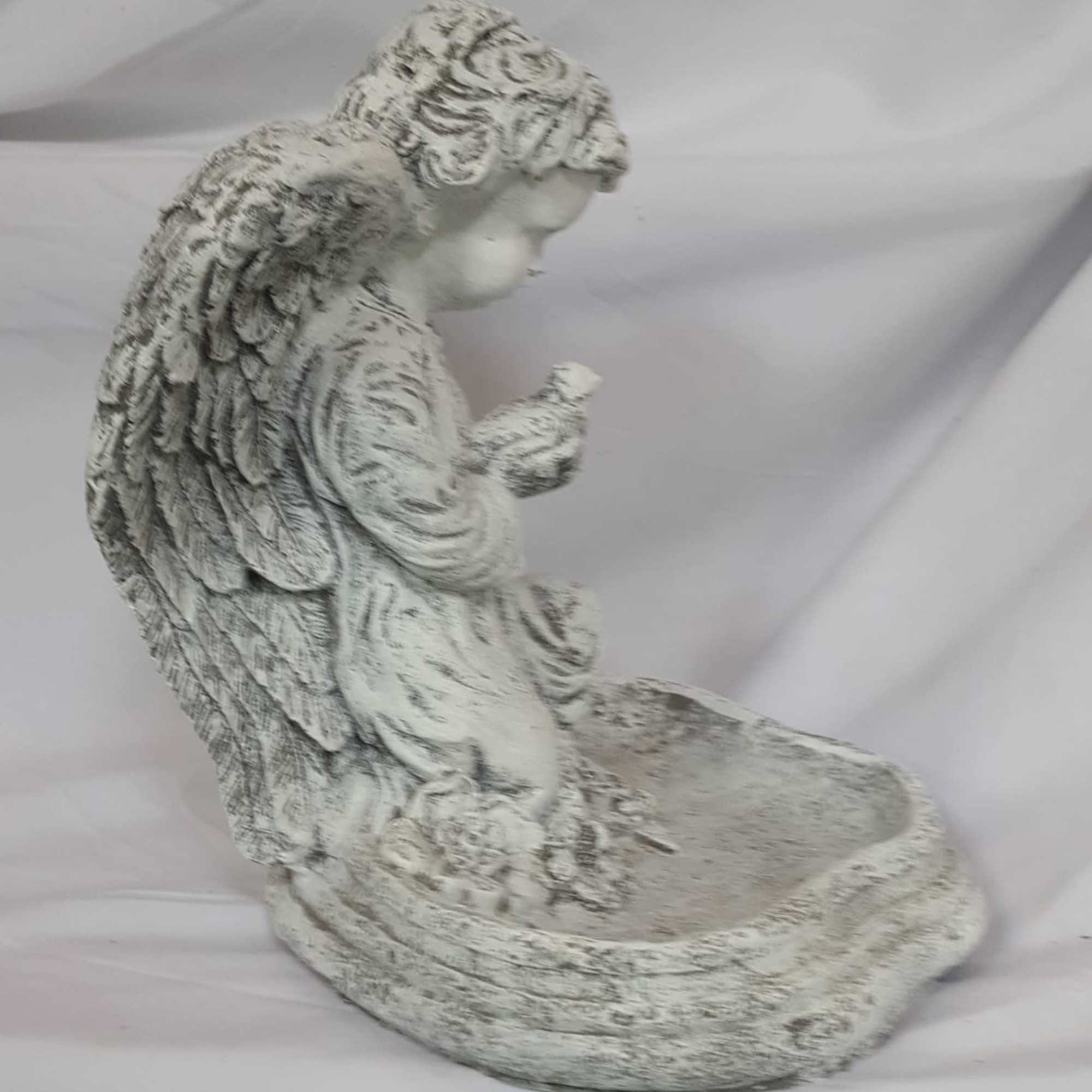 Weathered stone angel figurine kneeling beside a shallow bowl, suitable as a decorative planter or memorial accent.