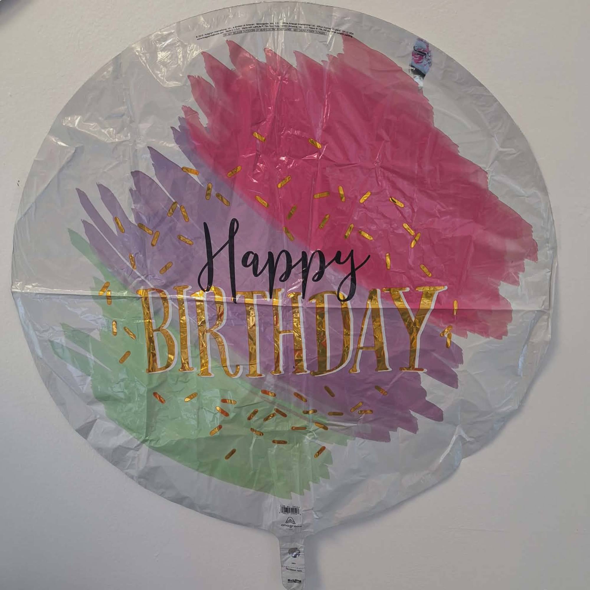 Round foil Happy Birthday balloon with pink, purple, and green brushstroke design