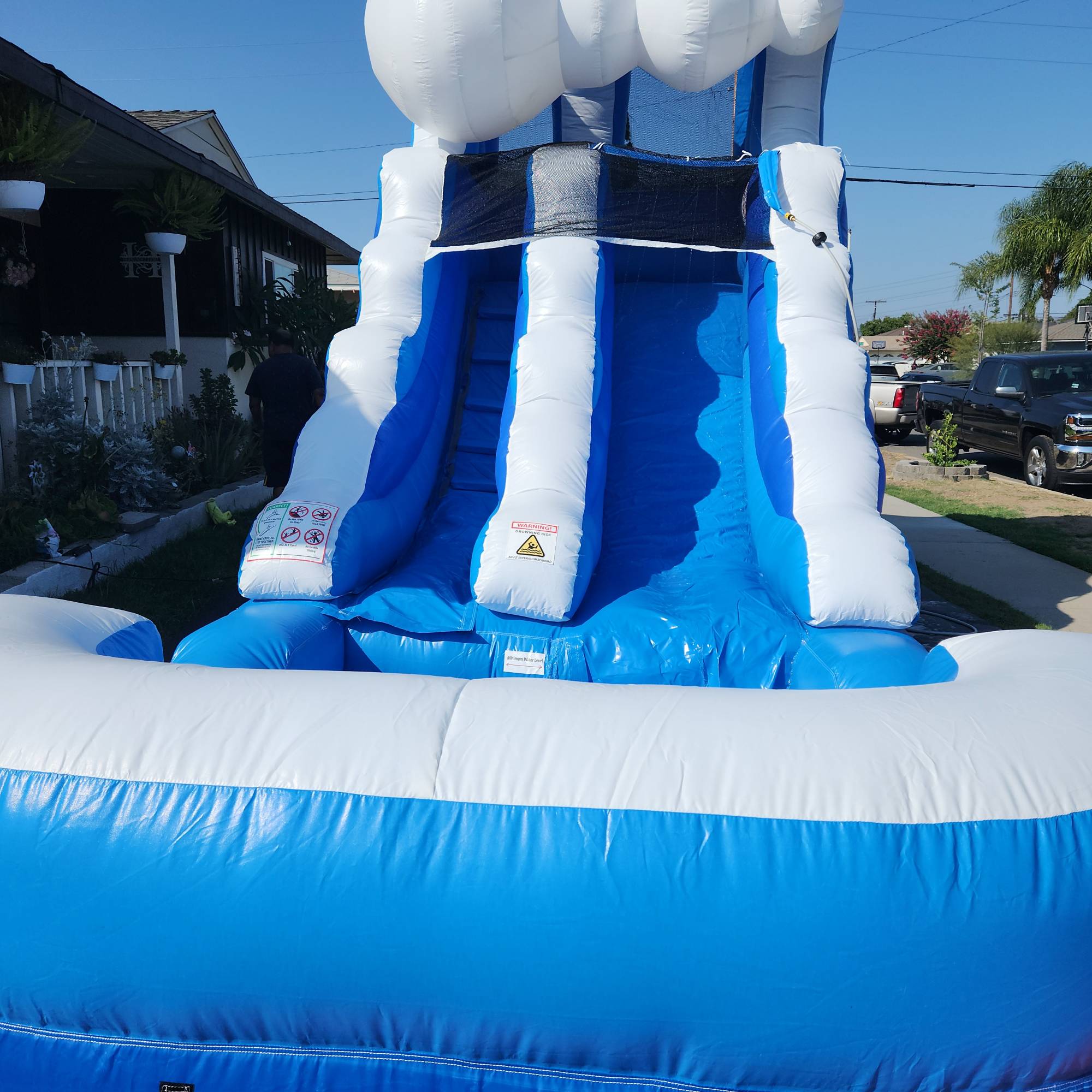 Large blue and white inflatable water slide set up outdoors on a sunny day