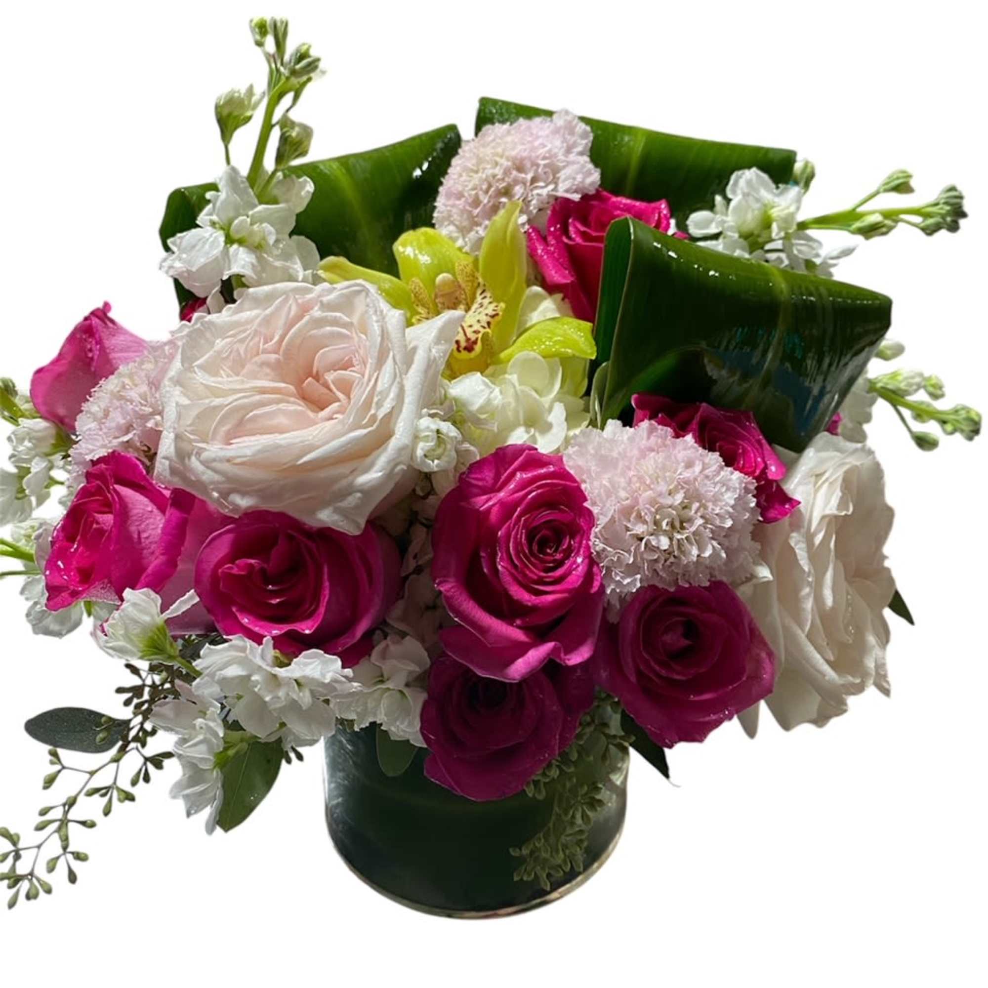 Compact arrangement of hot pink and white roses with green orchid in a short glass cylinder vase