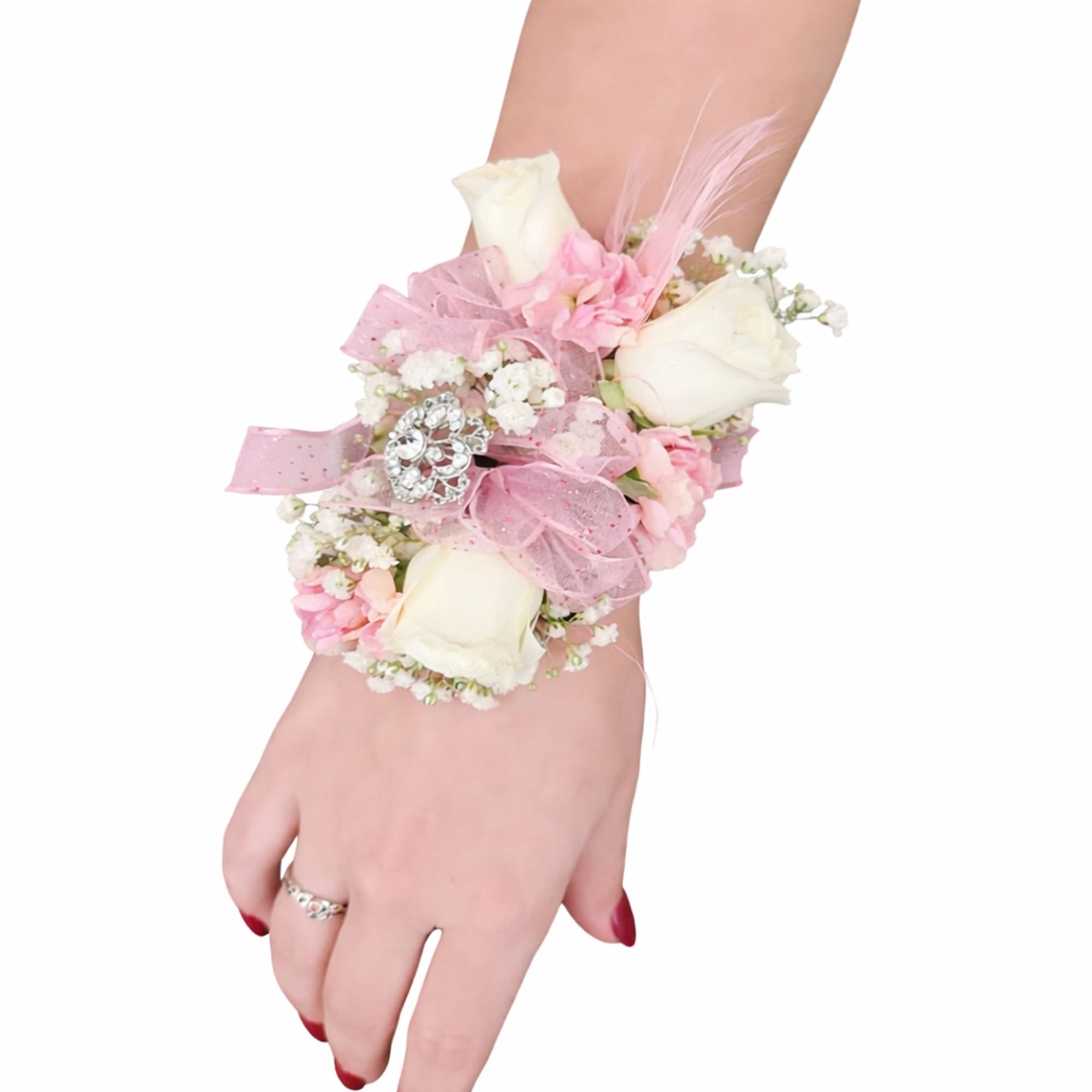 Wrist corsage with white roses, pink flowers, baby's breath, and pink ribbon on a woman's hand