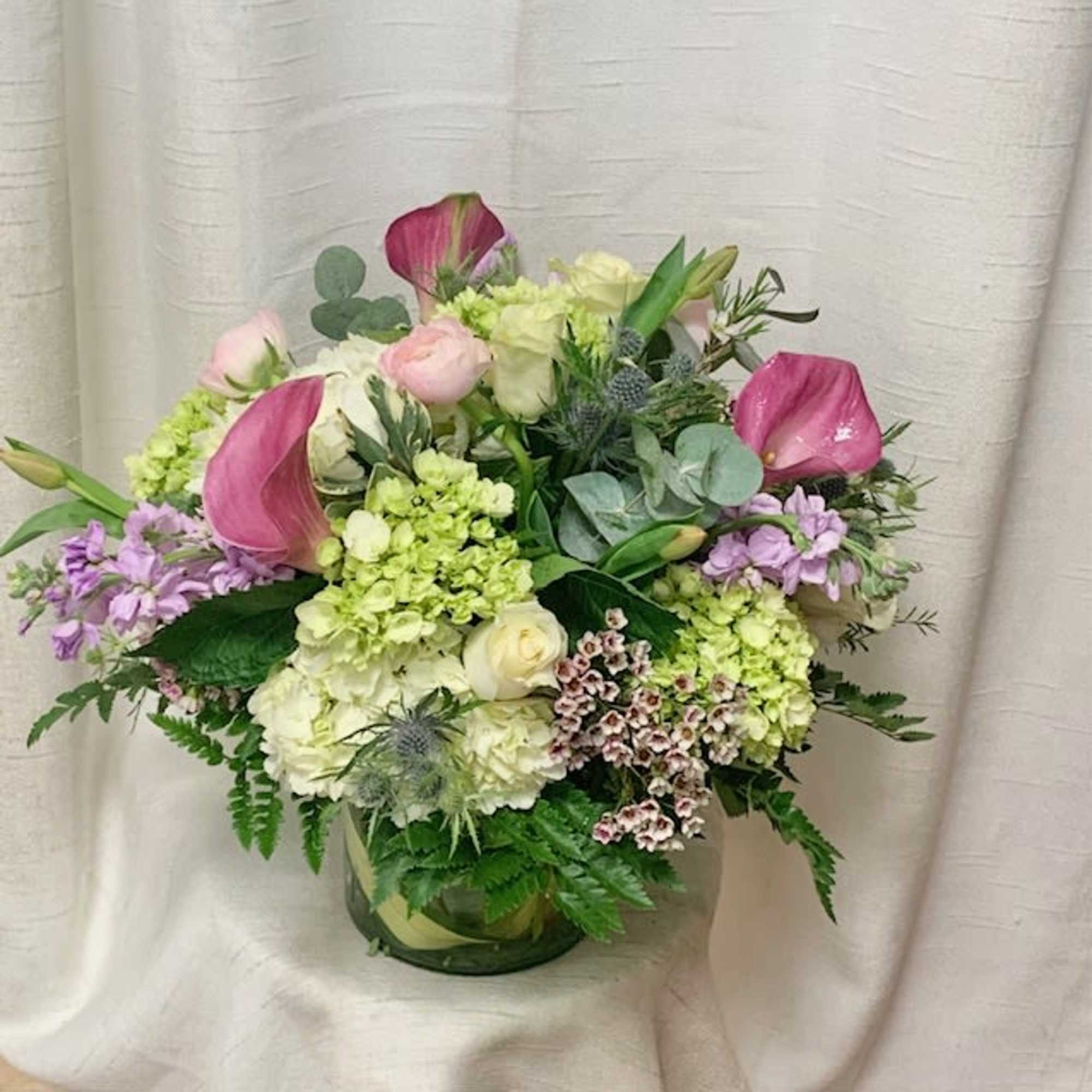 This arrangement boasts a delicate fusion of white and green Hydrangea, dark