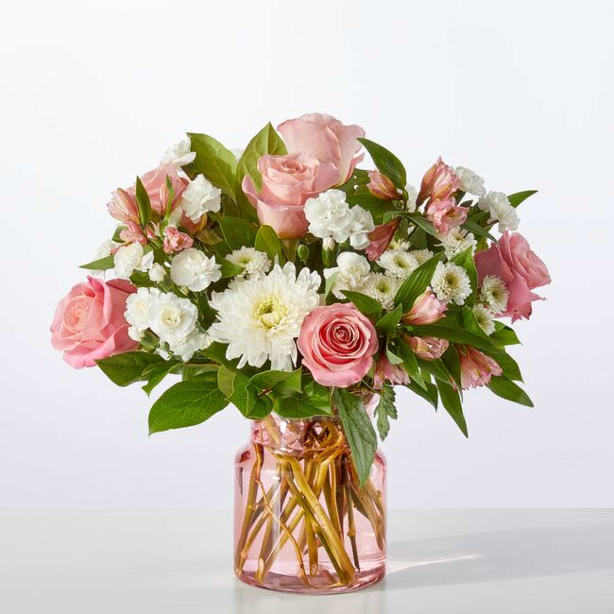 Pink roses and white daisies in a pink glass vase