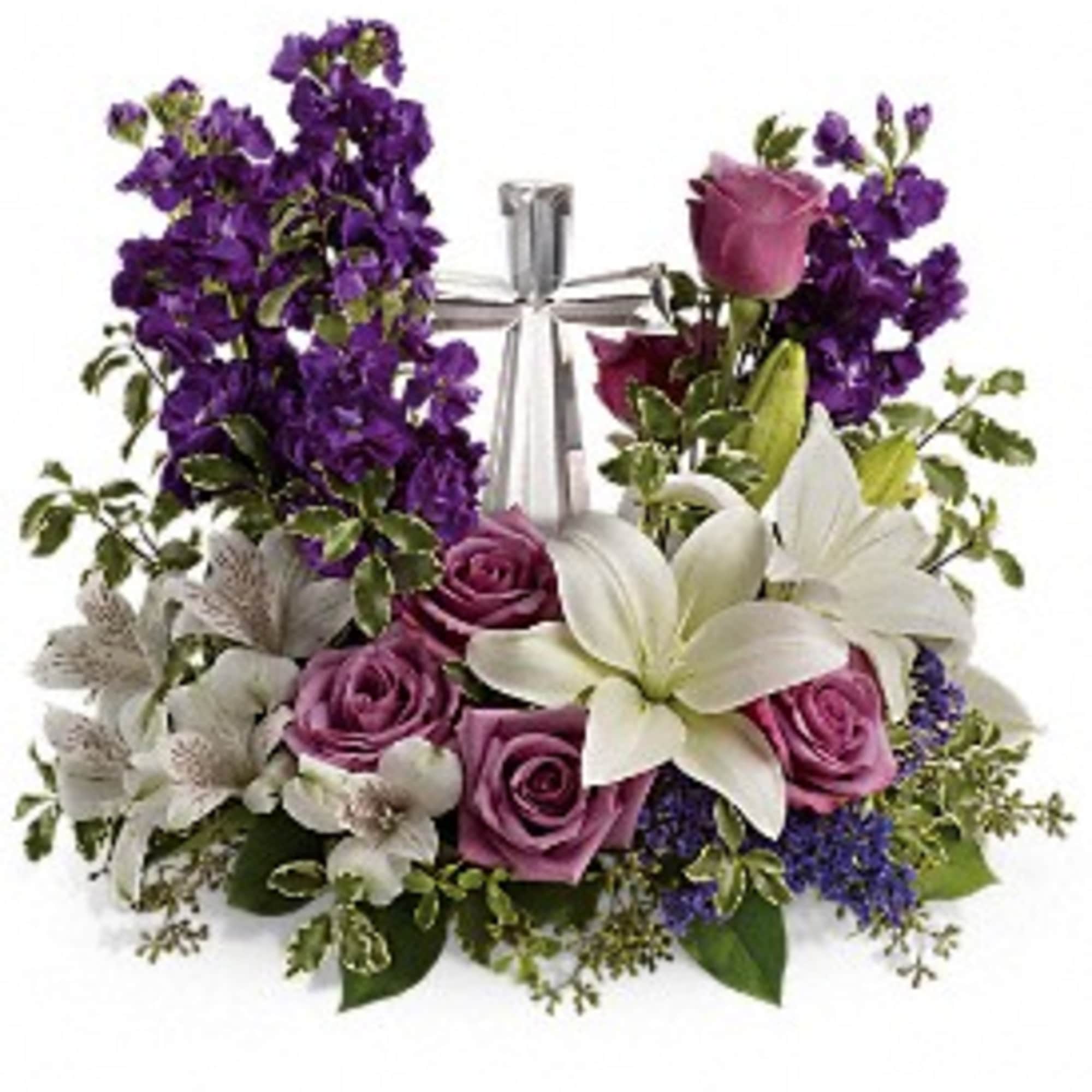 Purple and white floral arrangement with roses and lilies surrounding a glass cross.