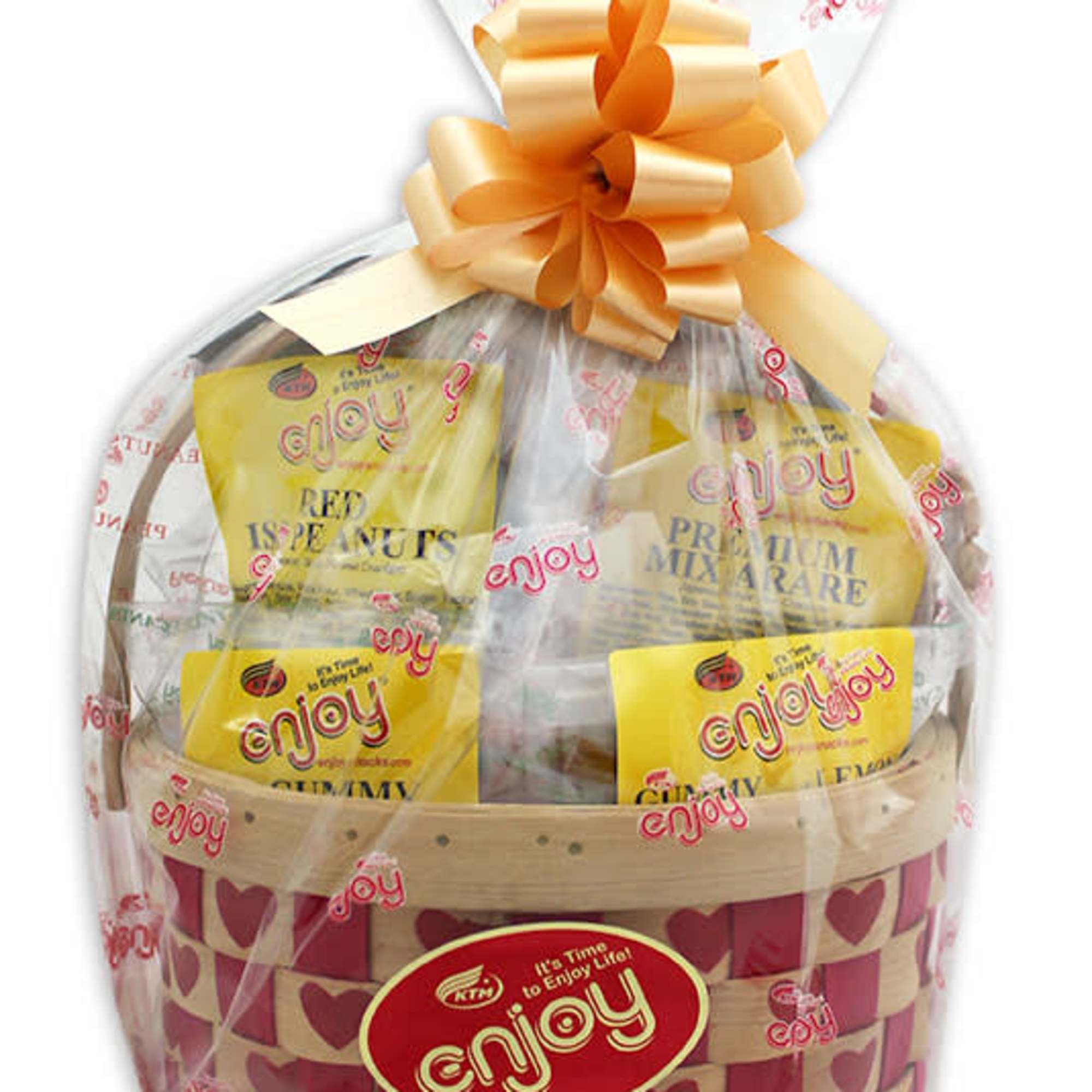 Wrapped snack gift basket with yellow packages in a heart-patterned woven basket and large peach bow