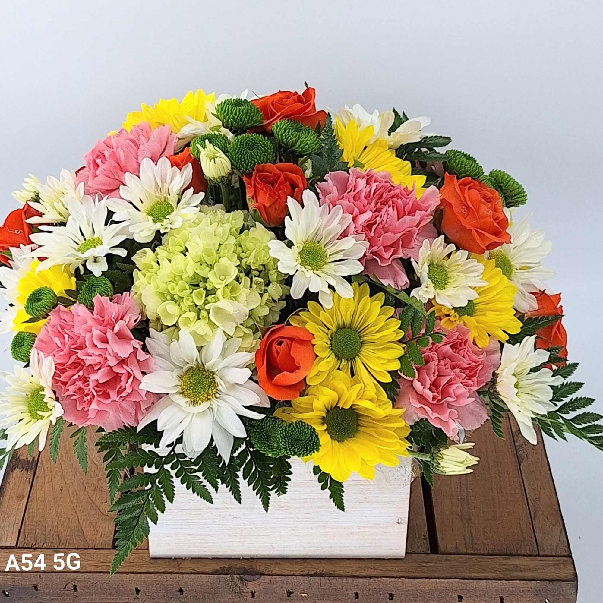Mixed bouquet in a white rectangular box with roses, carnations, daisies, and chrysanthemums