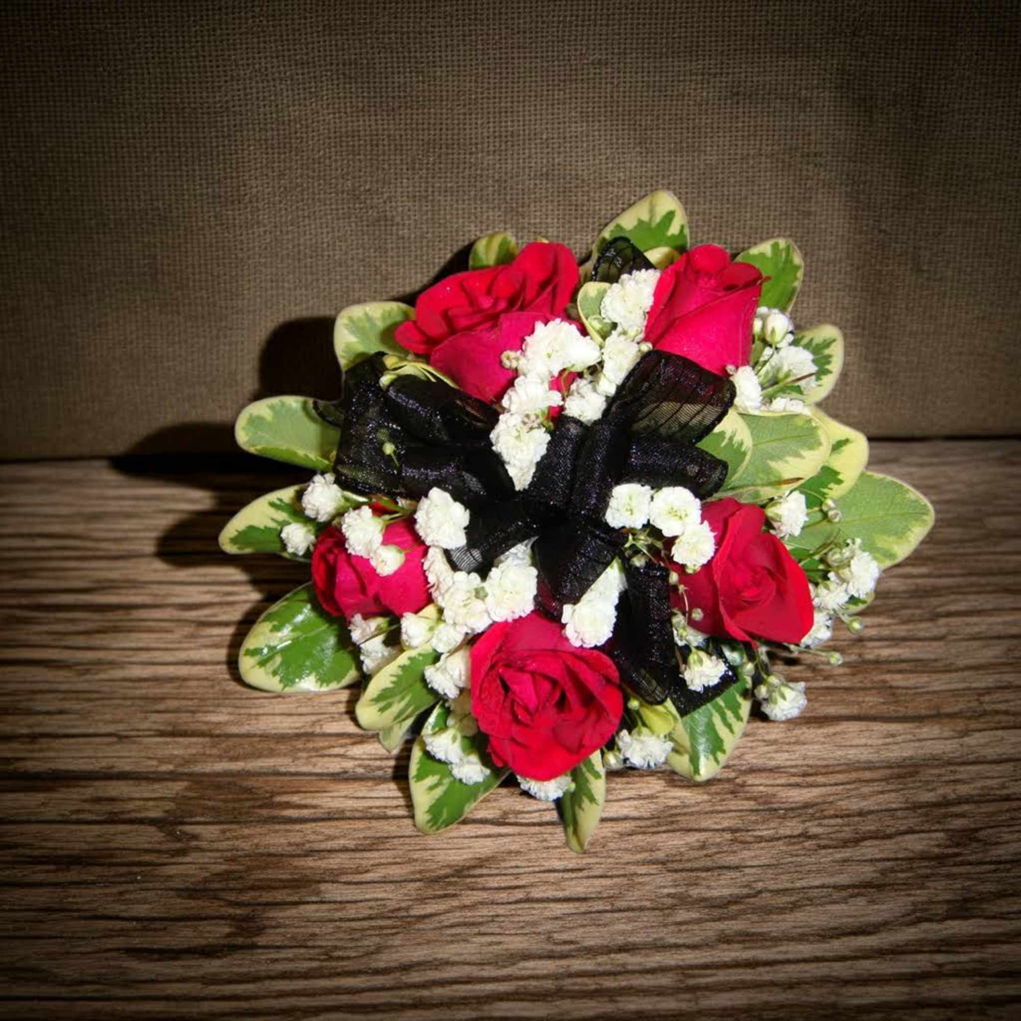 Small bouquet of red roses with white filler and a black ribbon