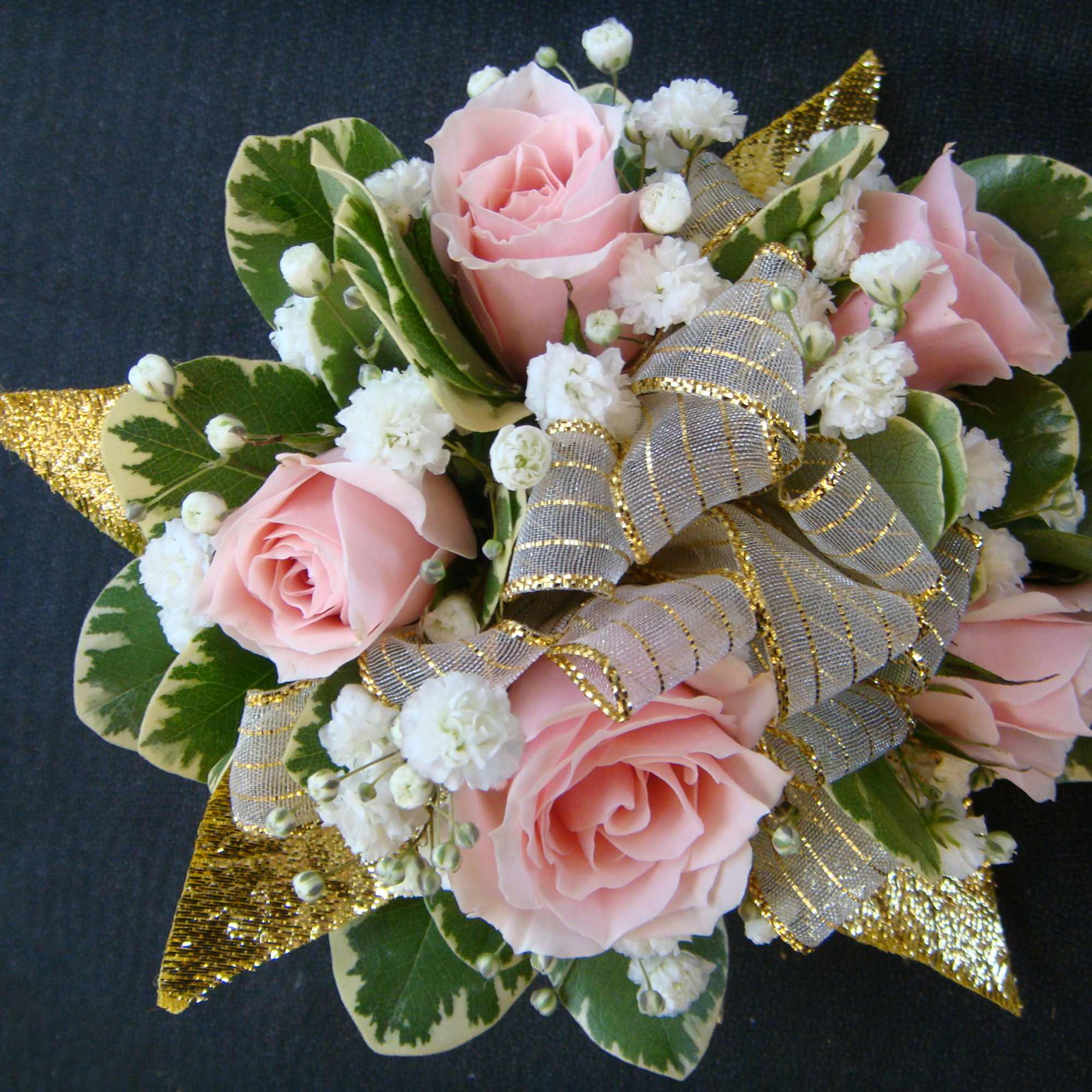Pink roses with white filler flowers and gold ribbon accents