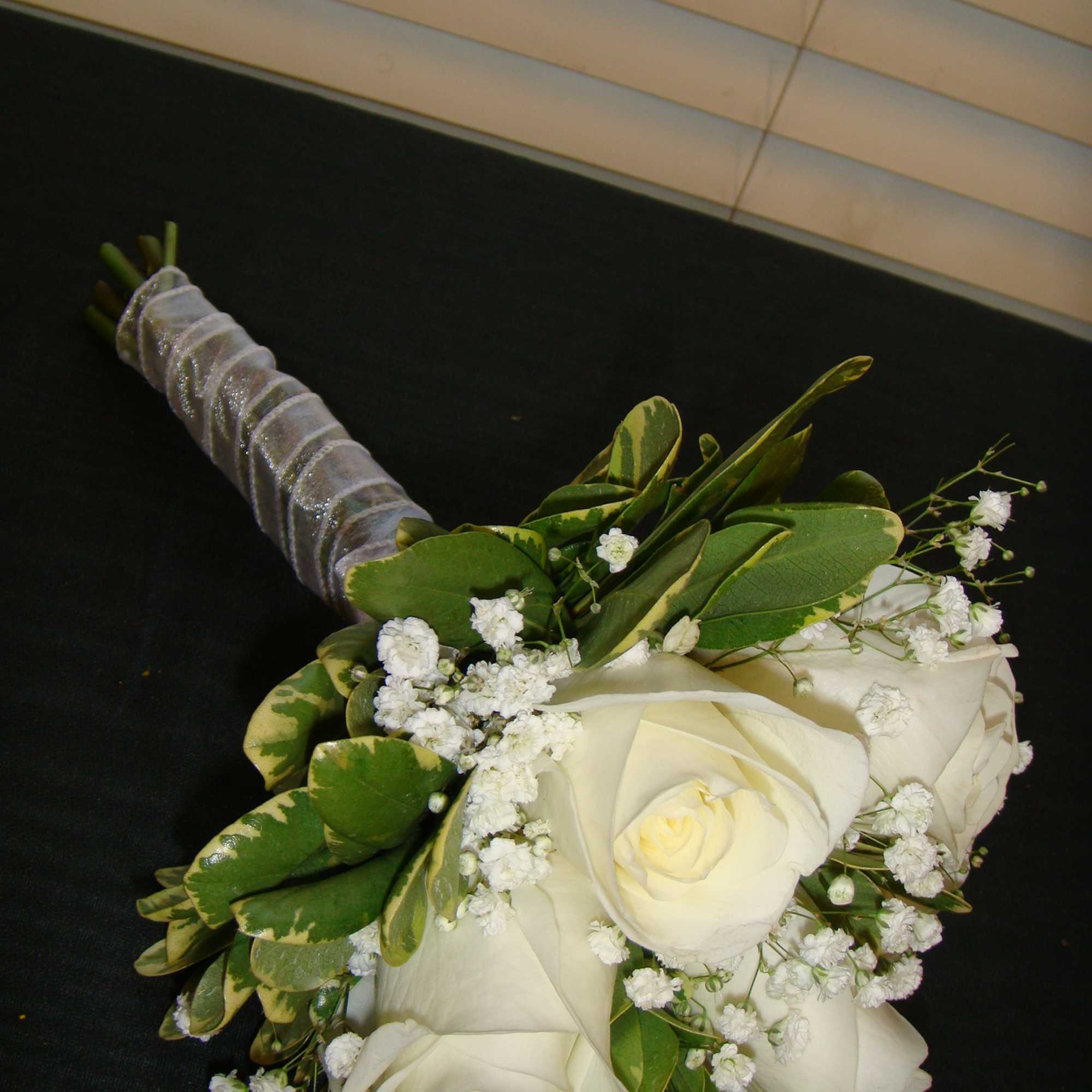 White rose bouquet with baby's breath and wrapped handle