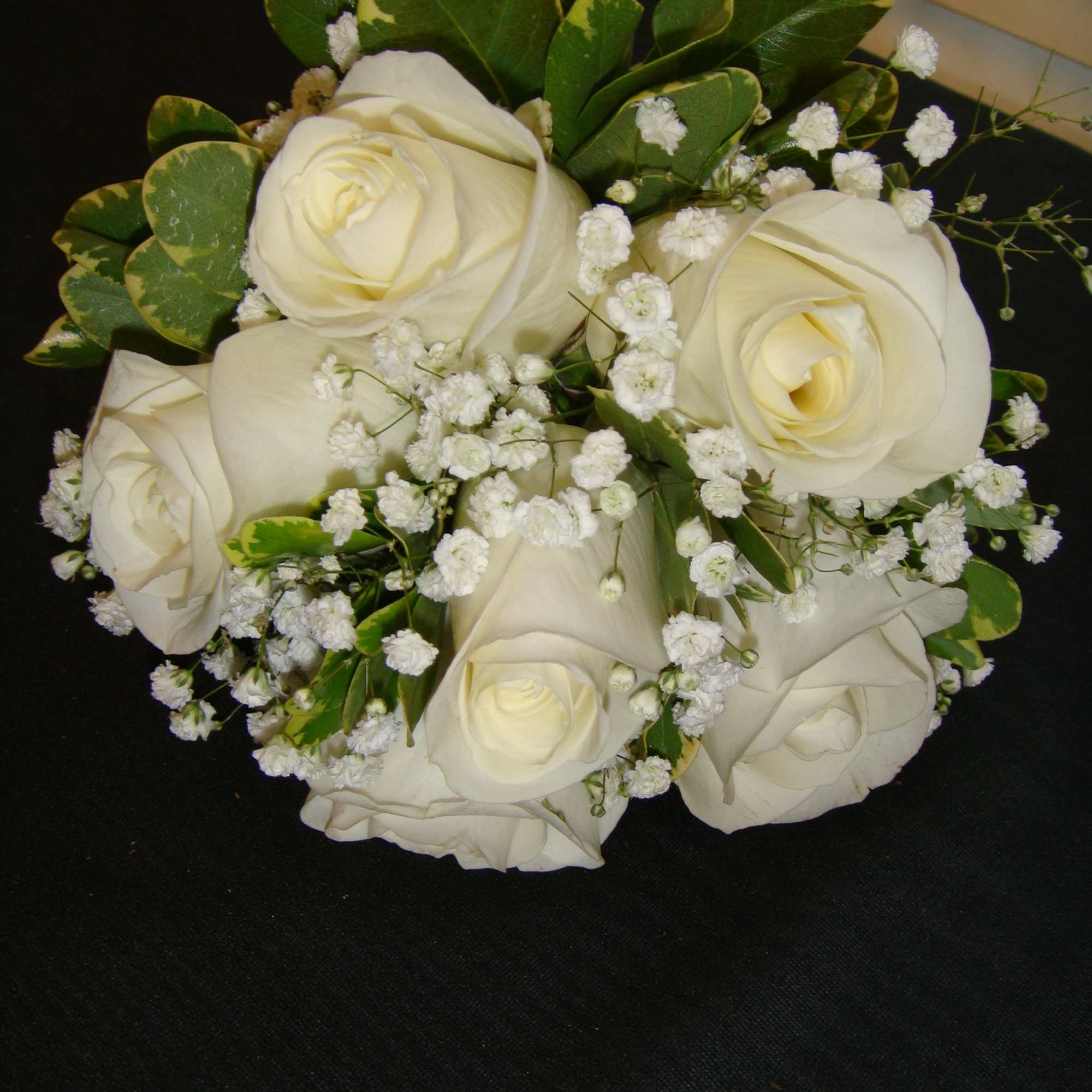 Bouquet of white roses with baby's breath and green foliage