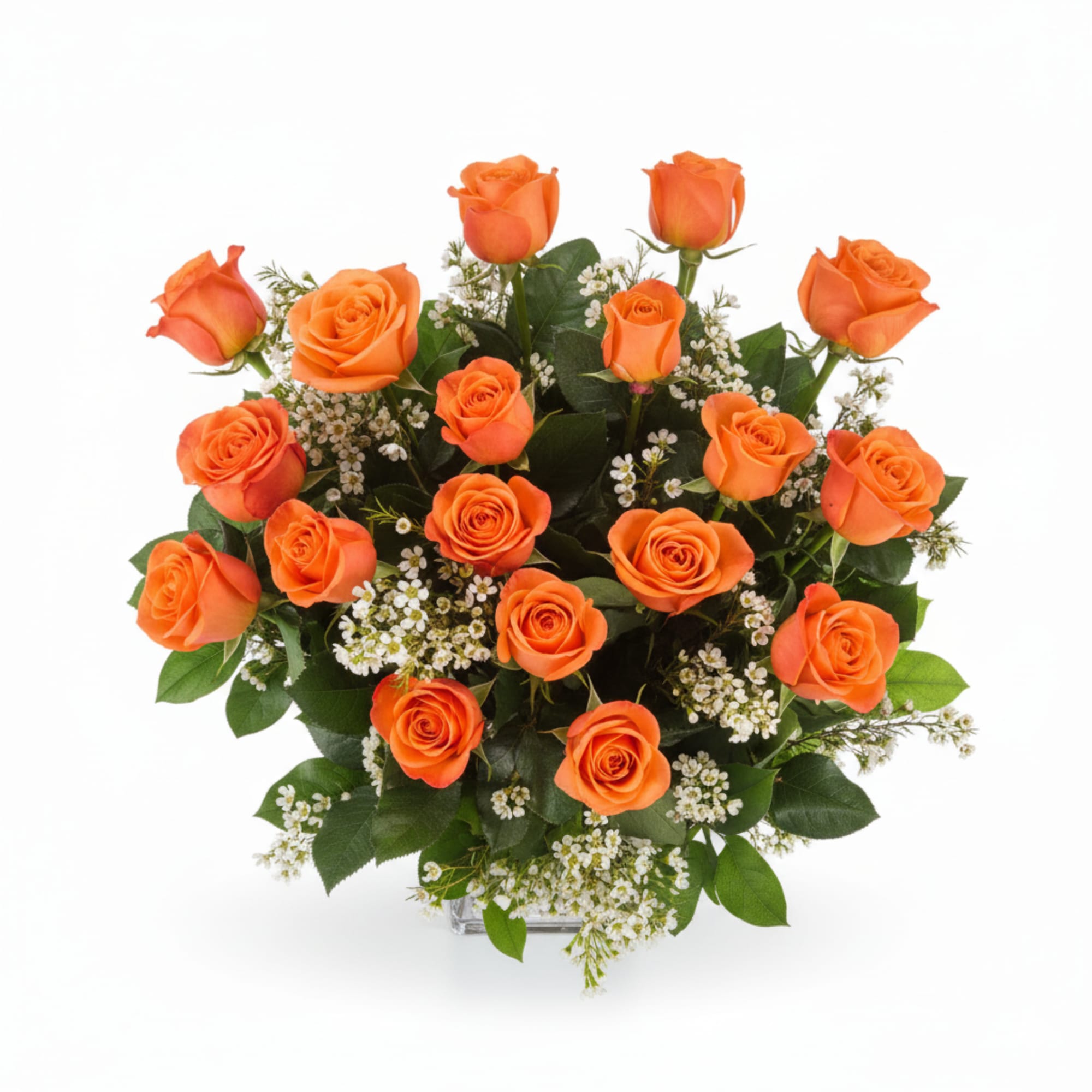 Arrangement of bright orange roses with small white filler flowers in a clear glass vase