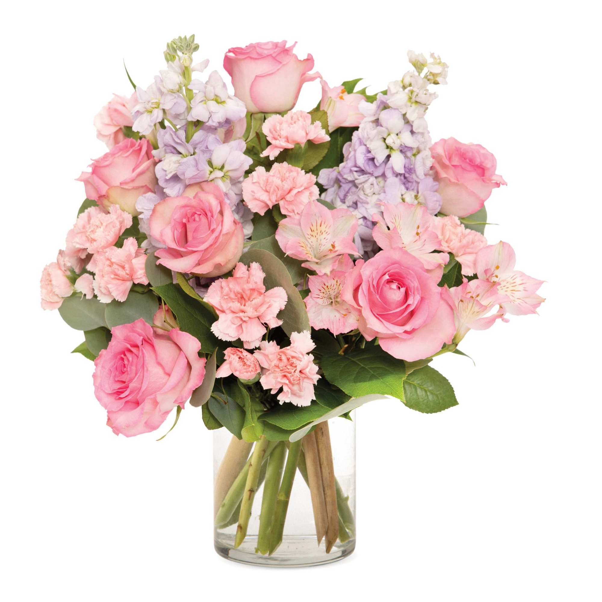 Pink and lavender bouquet of roses, carnations, and other blooms in a clear glass vase