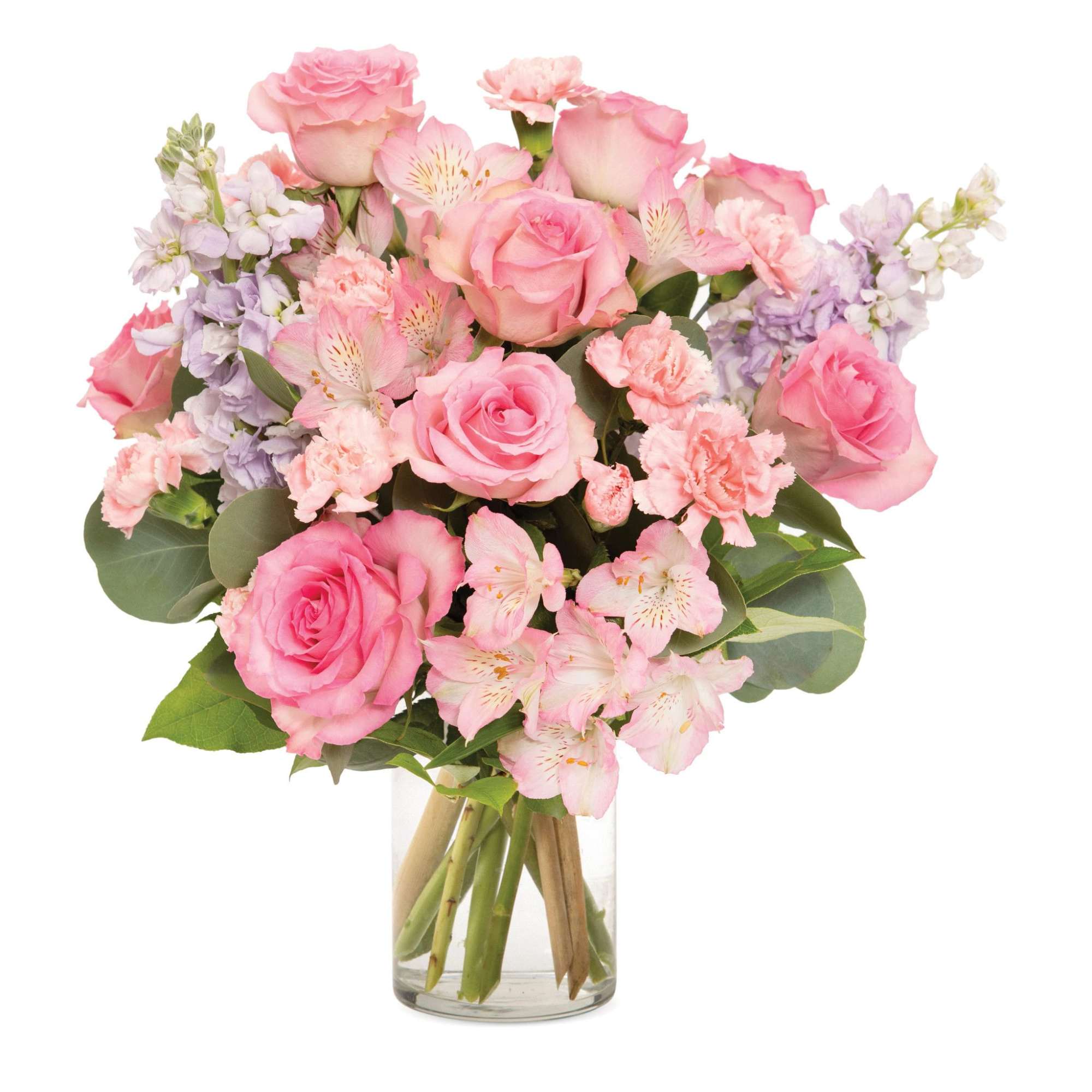 Pink roses, carnations, and alstroemeria with light lavender blooms arranged in a clear glass vase