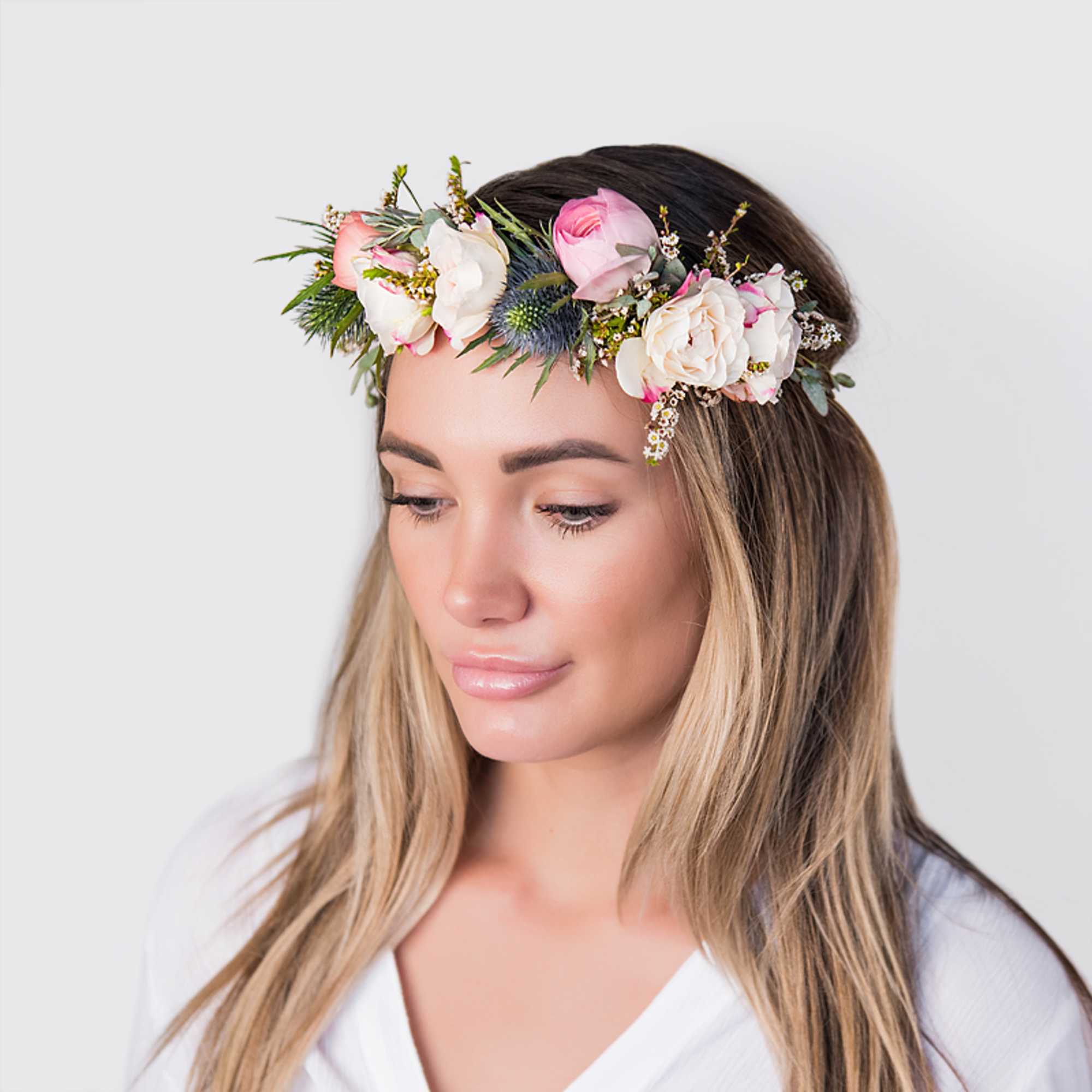 Woman wearing a pink and white floral crown headpiece on loose hair