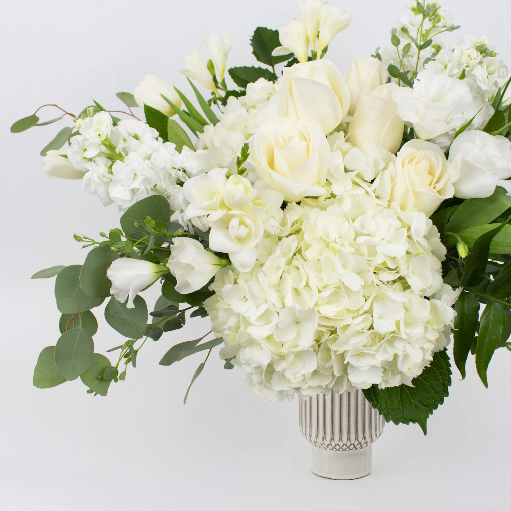 White floral arrangement in a clear ribbed vase