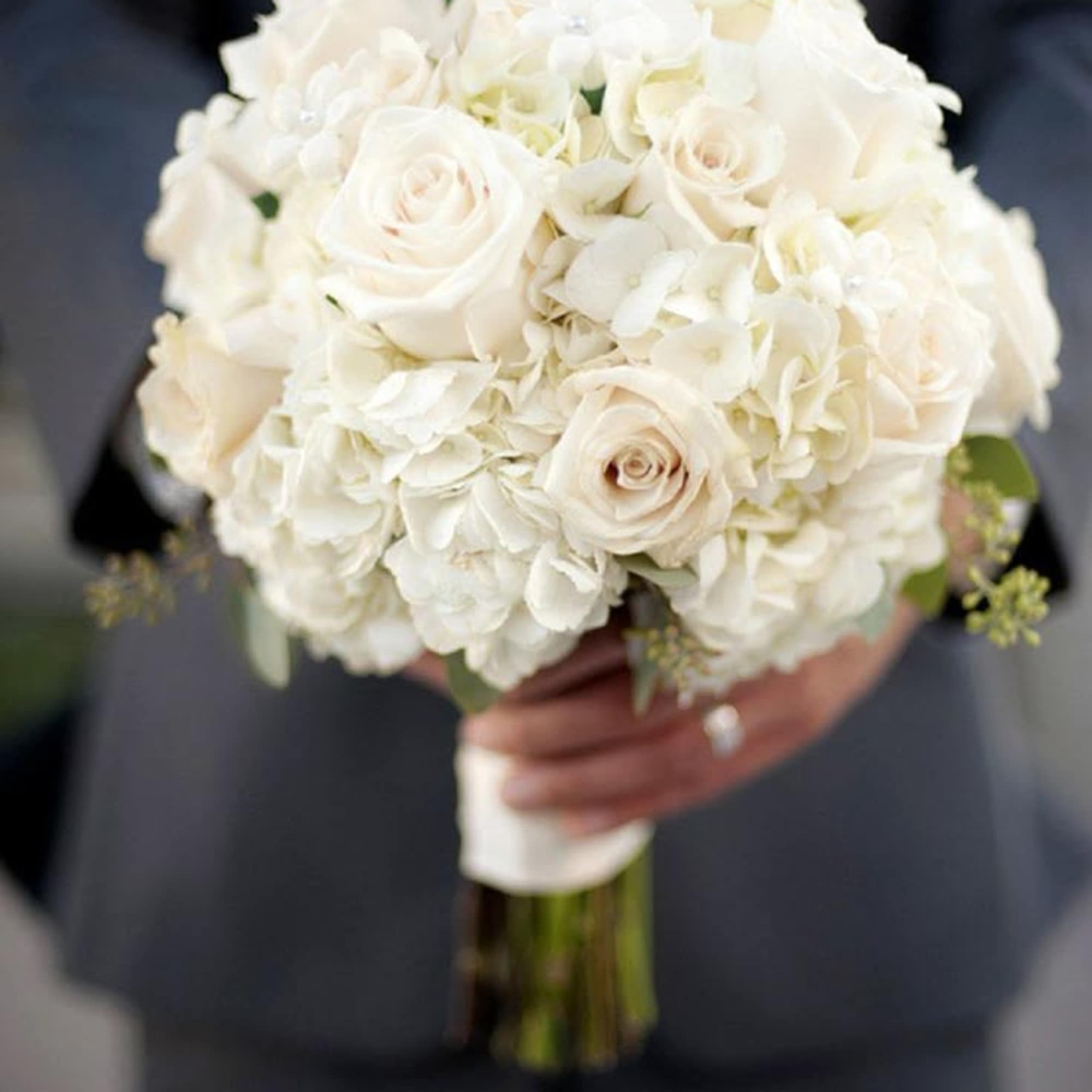 A timeless, romantic bouquet of ivory roses and white hydrangea with soft