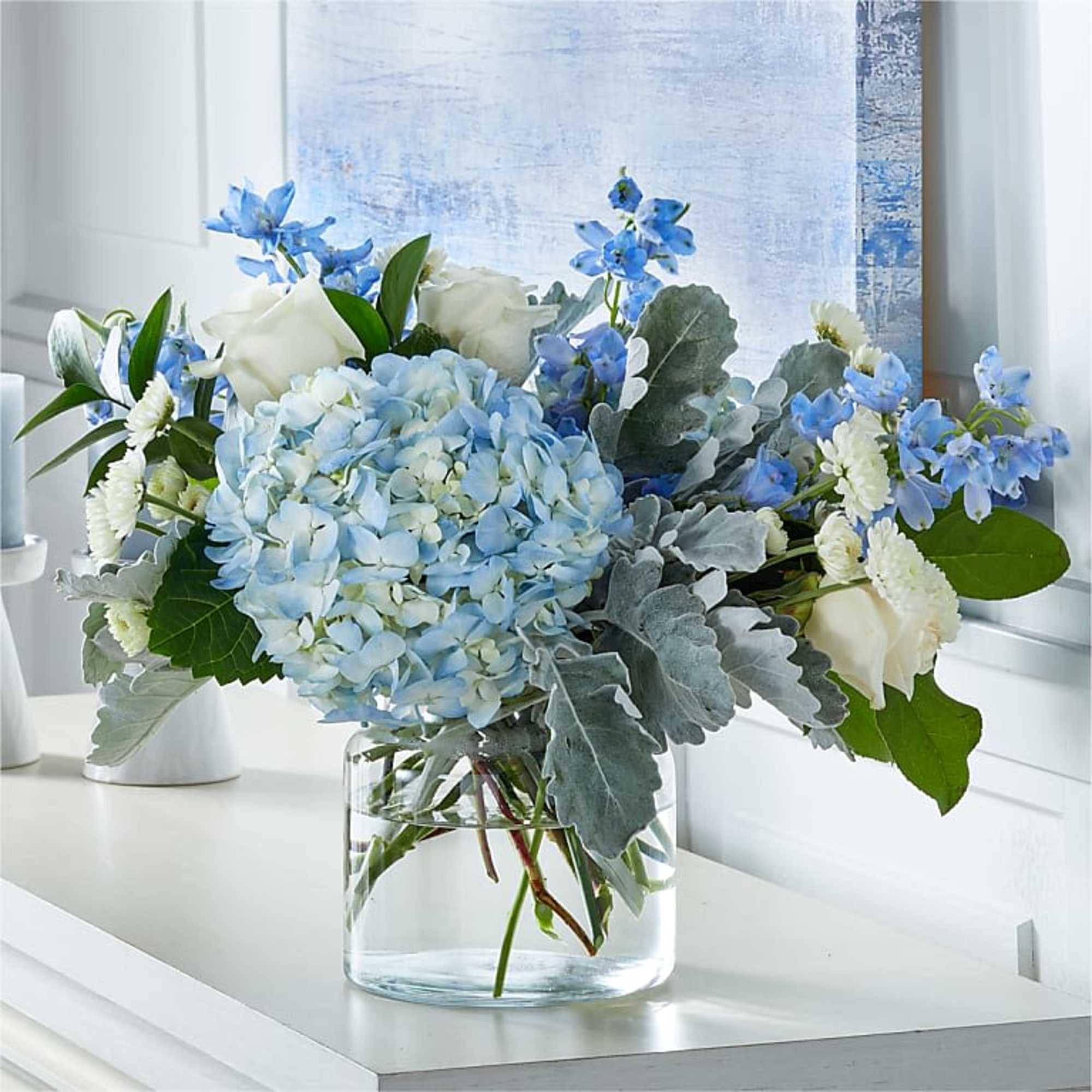 Blue and white flower arrangement in a clear glass vase