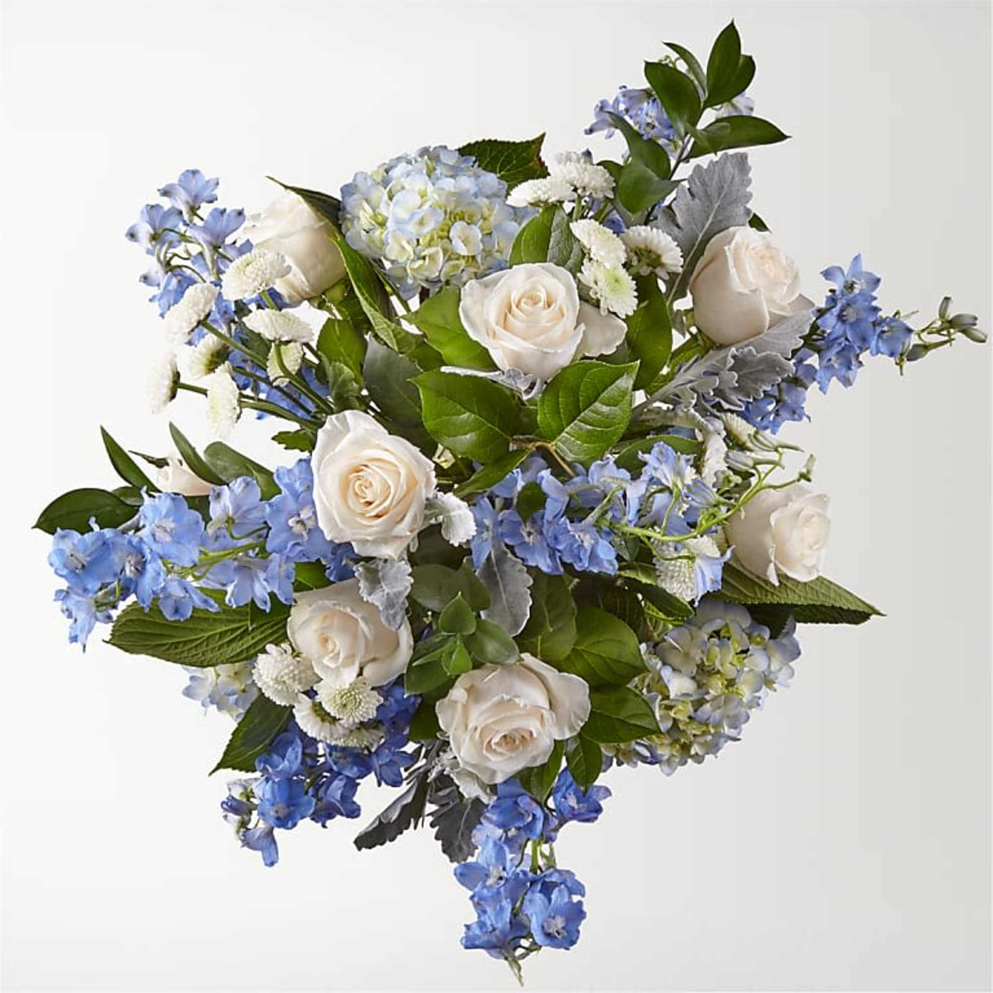 Bouquet of white roses and blue flowers with green foliage
