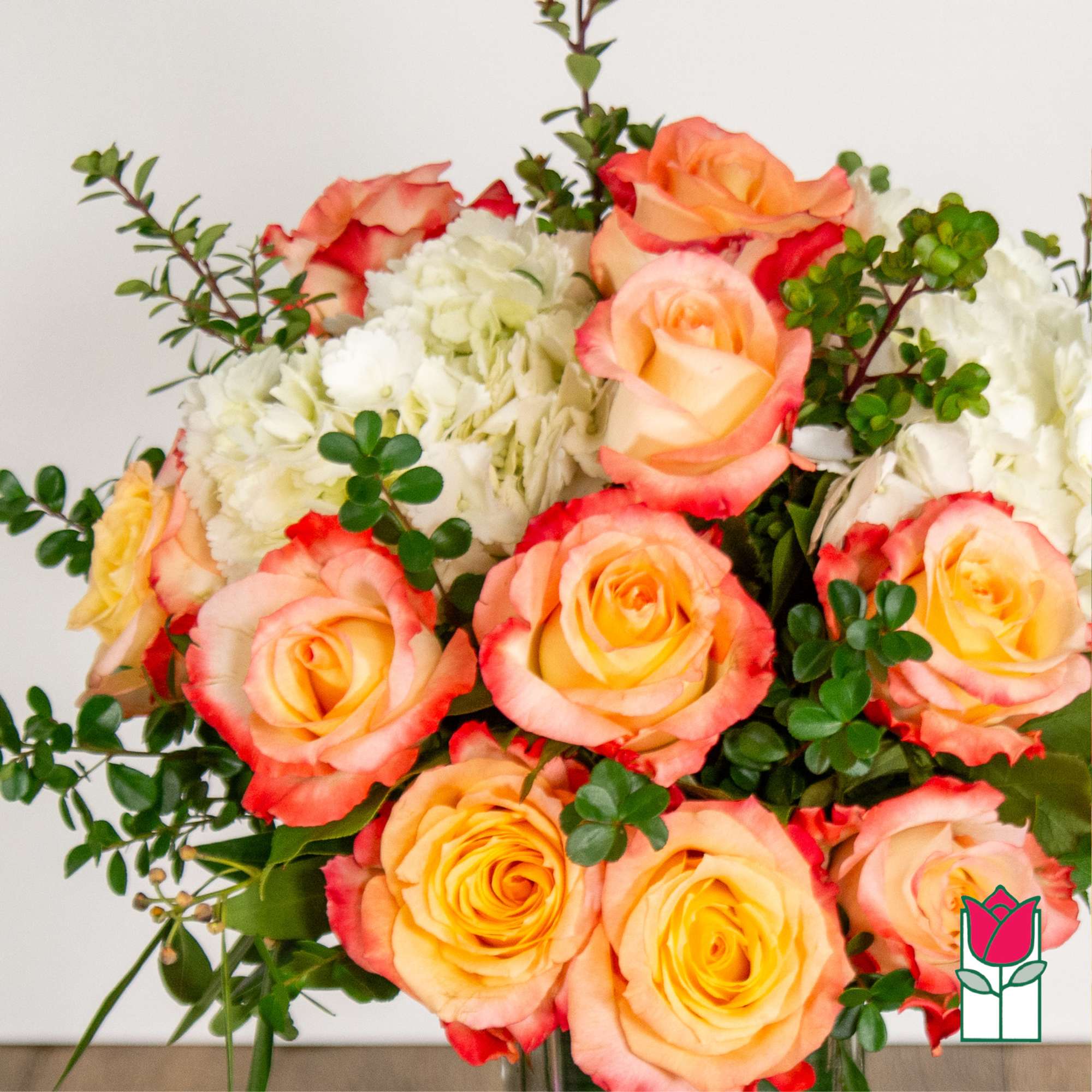 Bouquet of peach and pink roses with white flowers and greenery