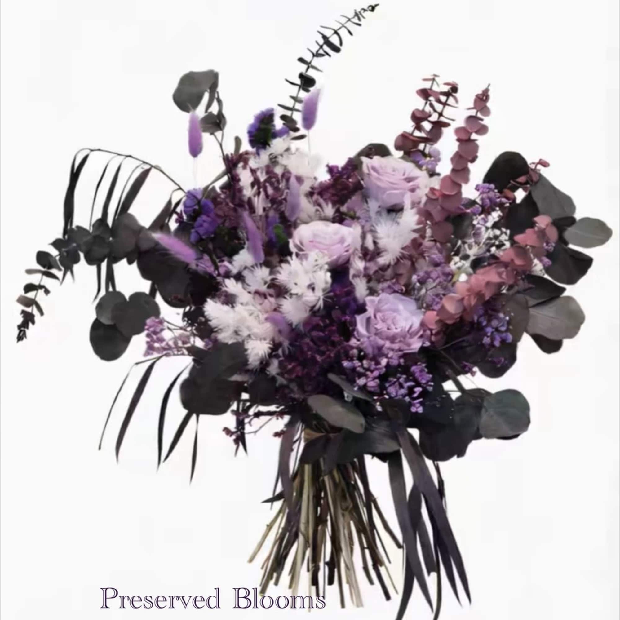 Hand-tied bouquet of preserved purple, lavender, and white flowers with dark foliage.