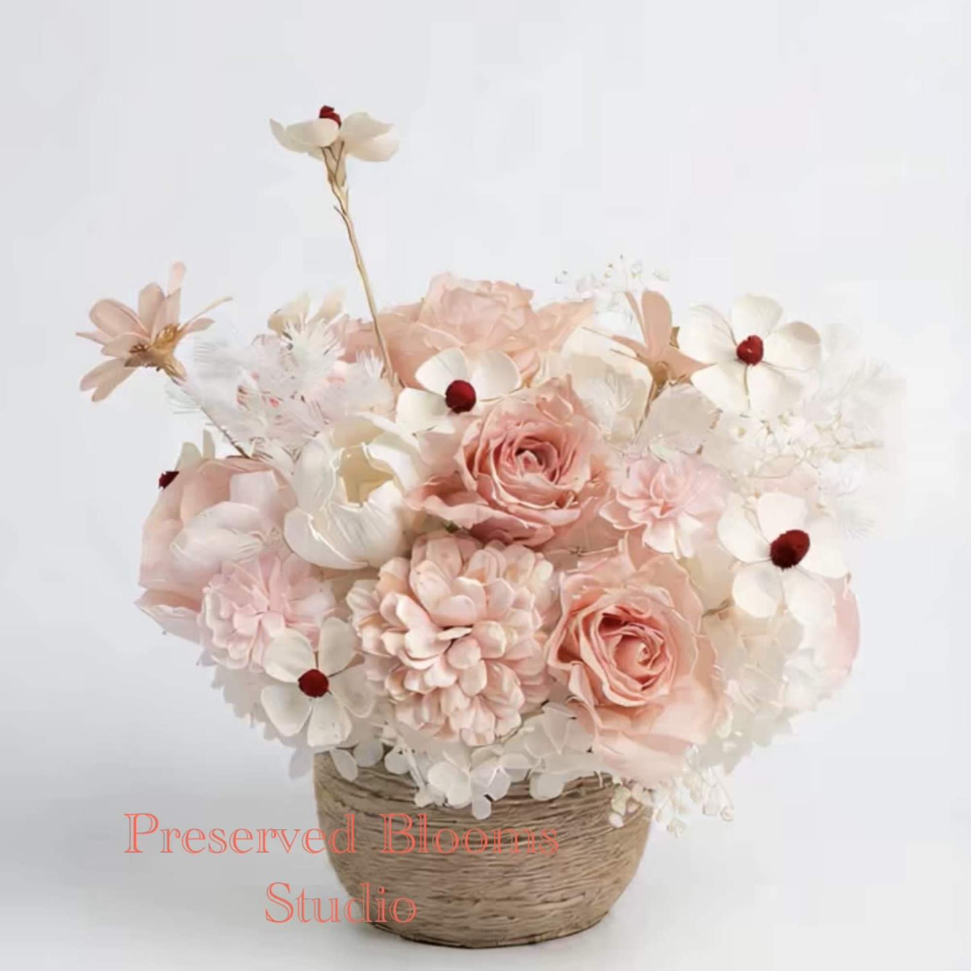 Pastel peach and white flower arrangement in a woven basket