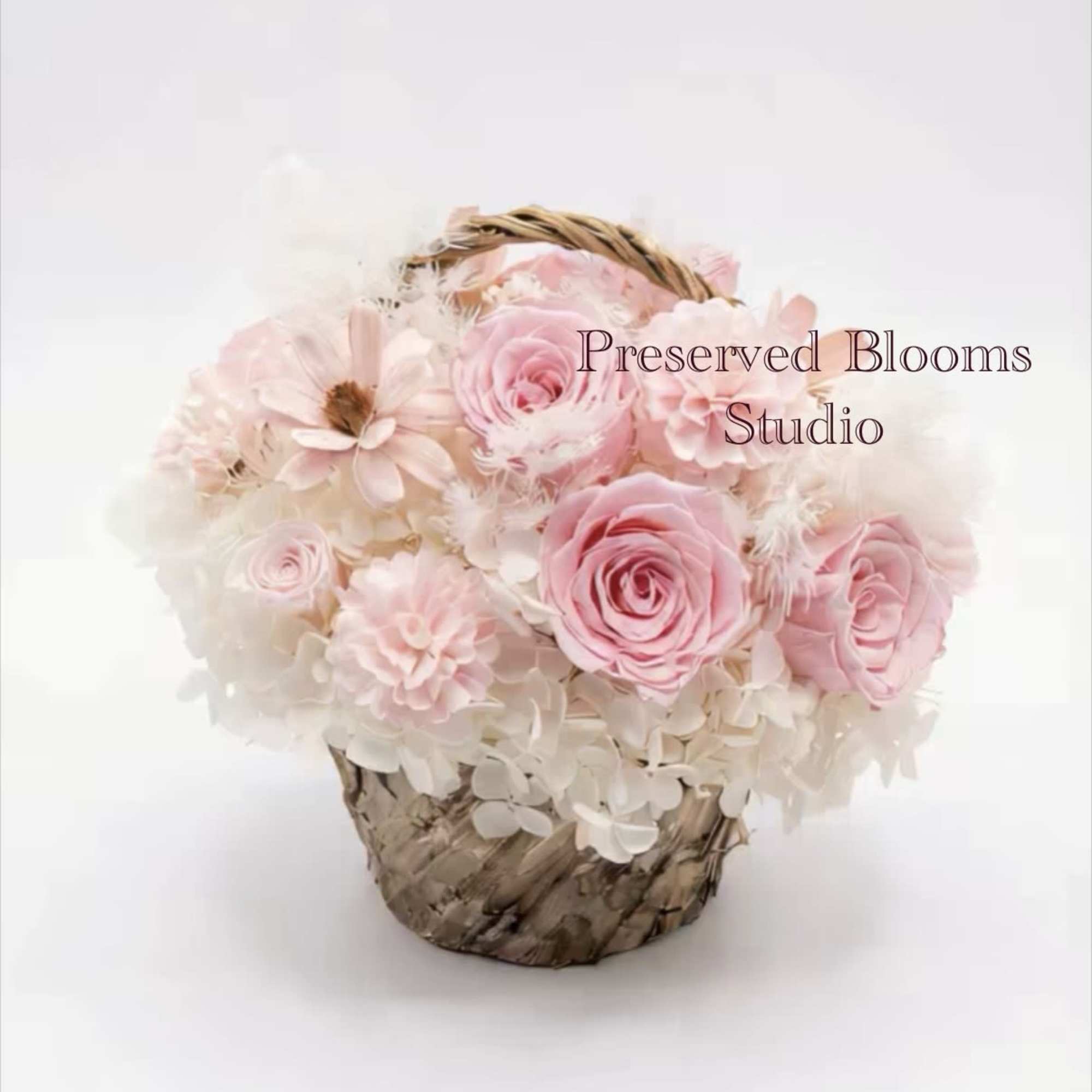 Pink and white roses arranged in a small woven basket.