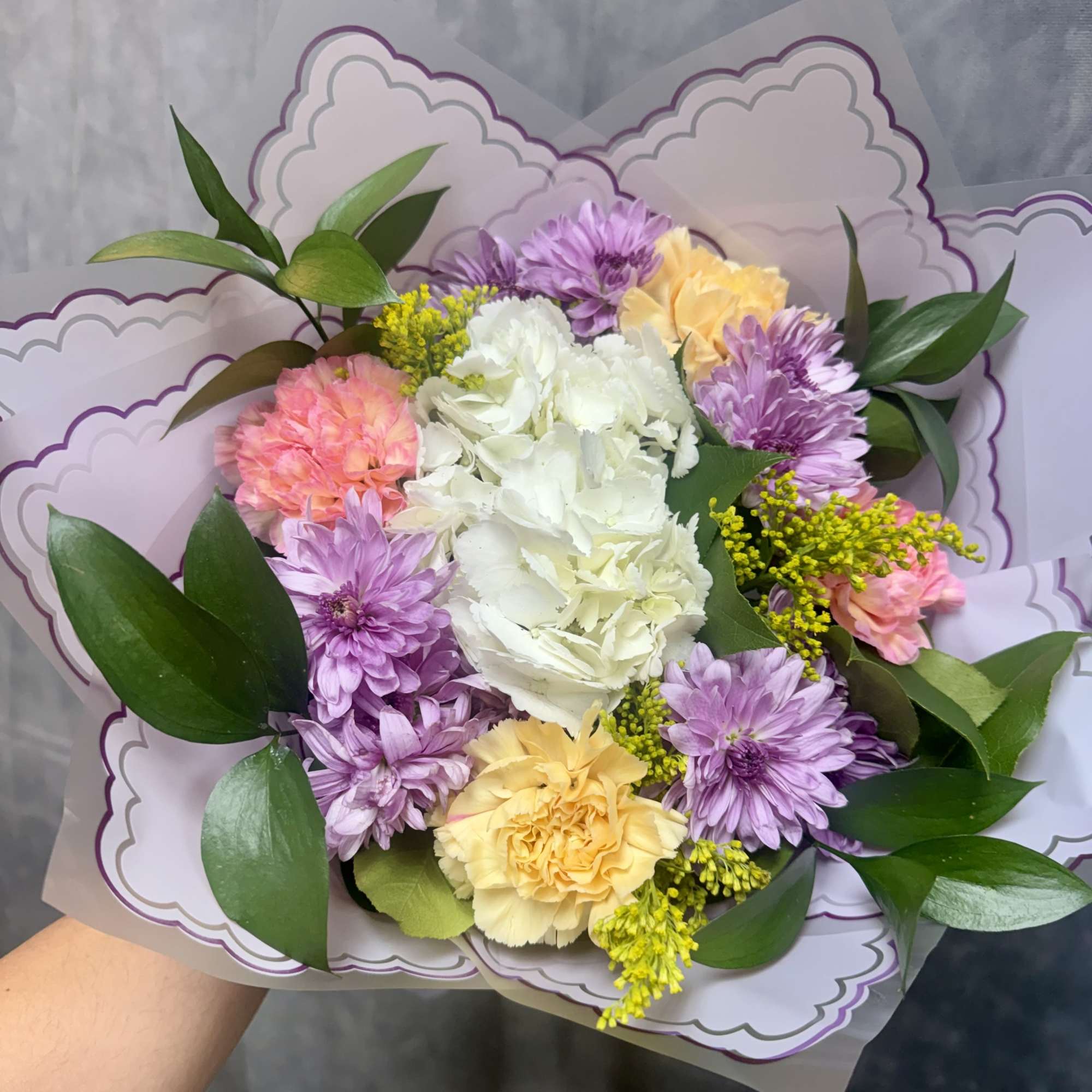Bouquet of pastel flowers with purple wrapping
