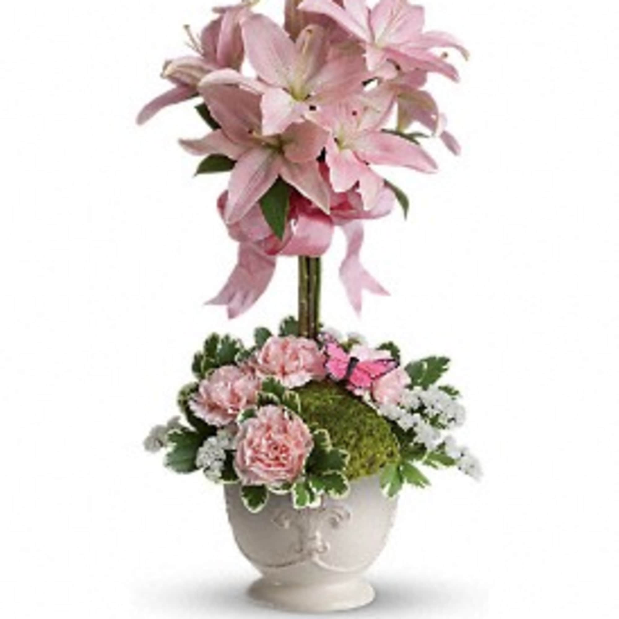 Tall pink lily topiary with pink carnations and white filler flowers in a white ceramic urn.
