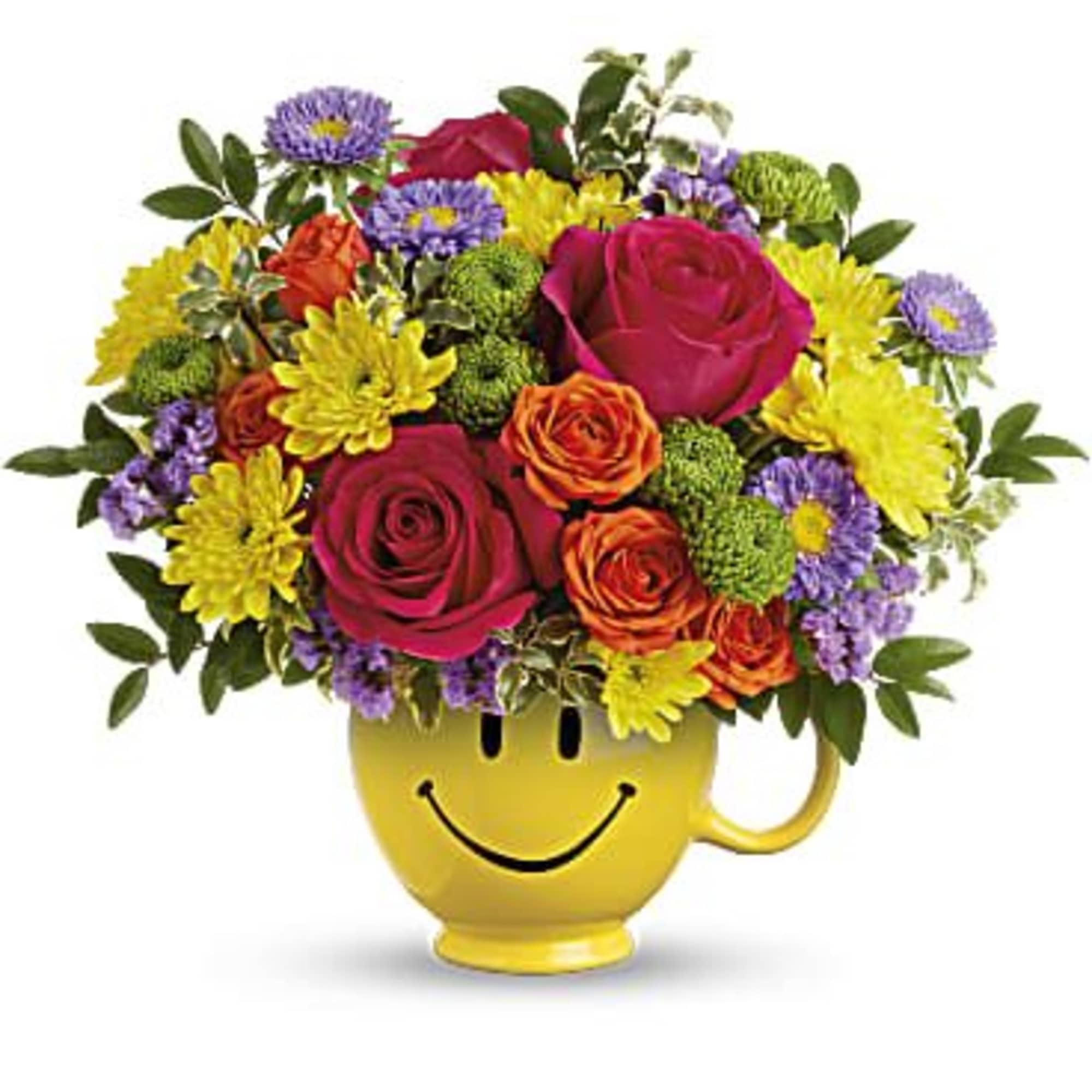Bright mixed bouquet of roses, mums, and asters in a yellow smiley-face mug.