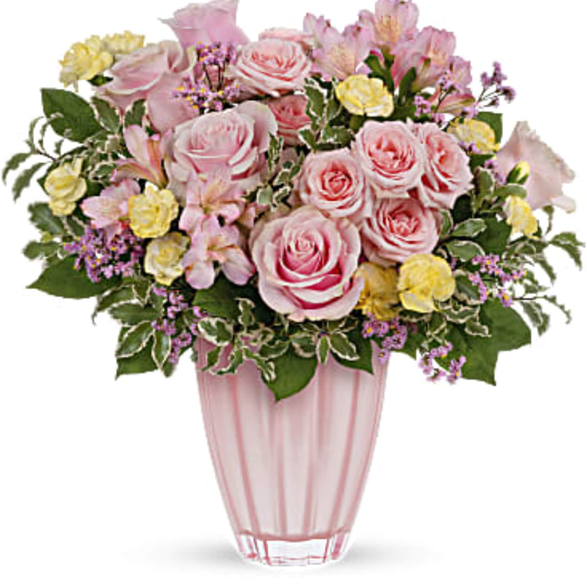 Arrangement of pink roses with yellow blooms in a pastel pink glass vase