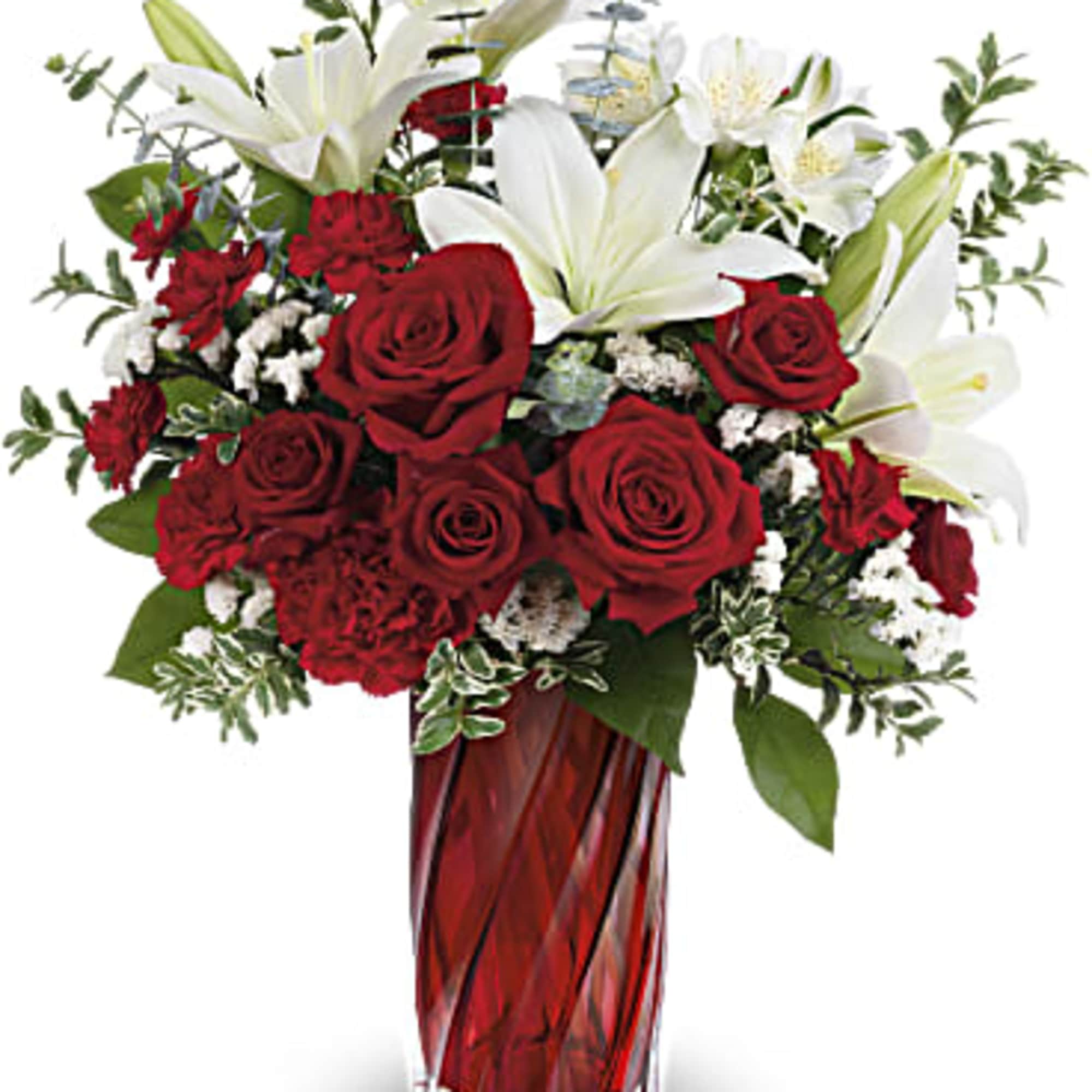 Arrangement of red roses and carnations with white lilies in a tall red glass vase
