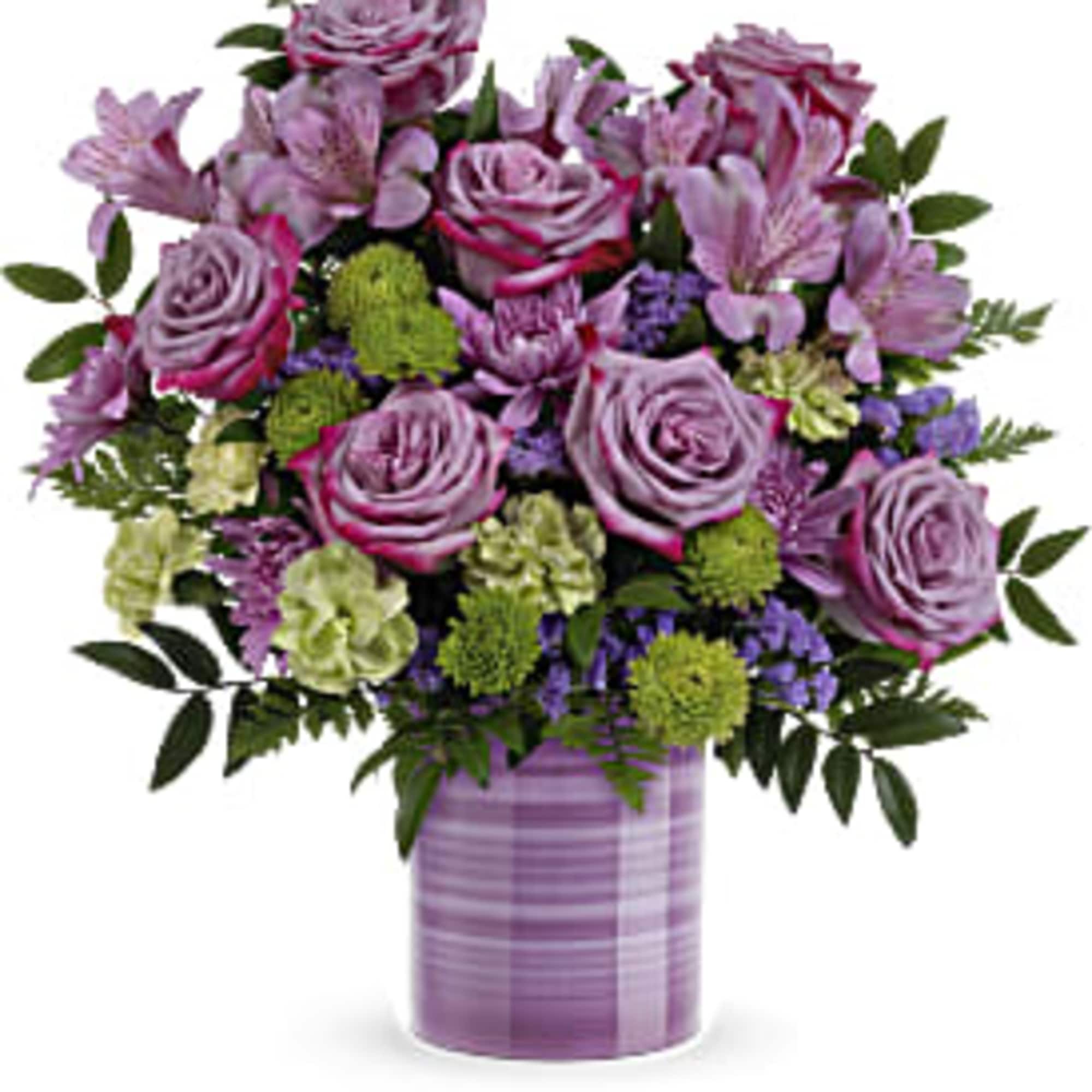 Lavender roses with purple blooms and green accents in a striped lavender vase