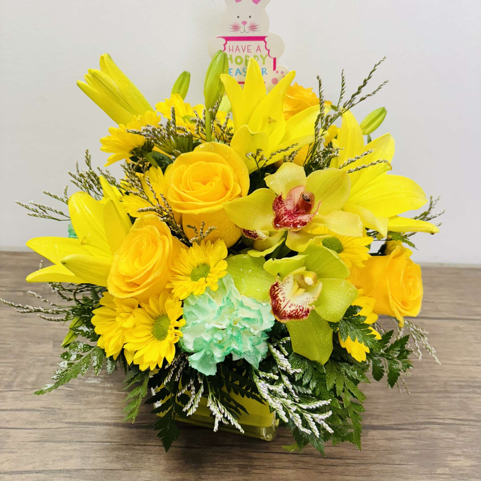 A bright and uplifting arrangement designed in a yellow vase, featuring open