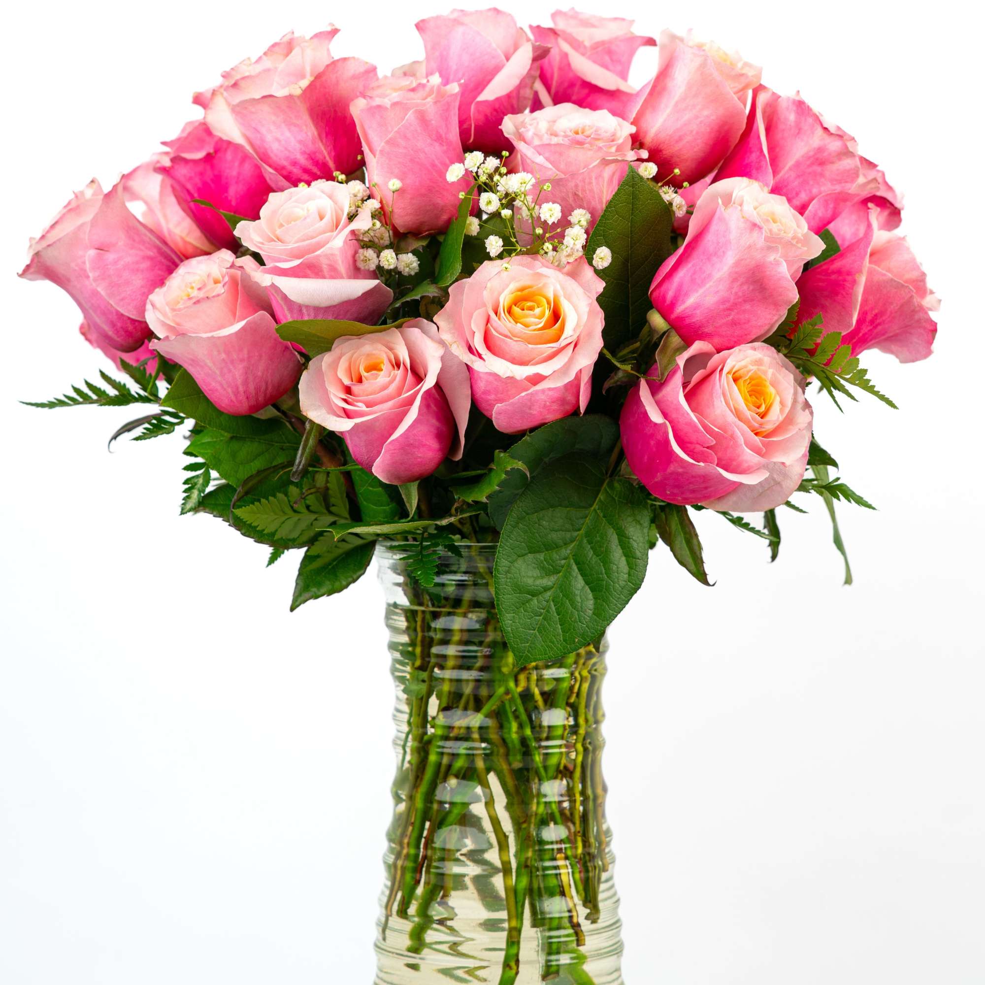 Tall arrangement of pink roses with baby's breath in a clear glass vase