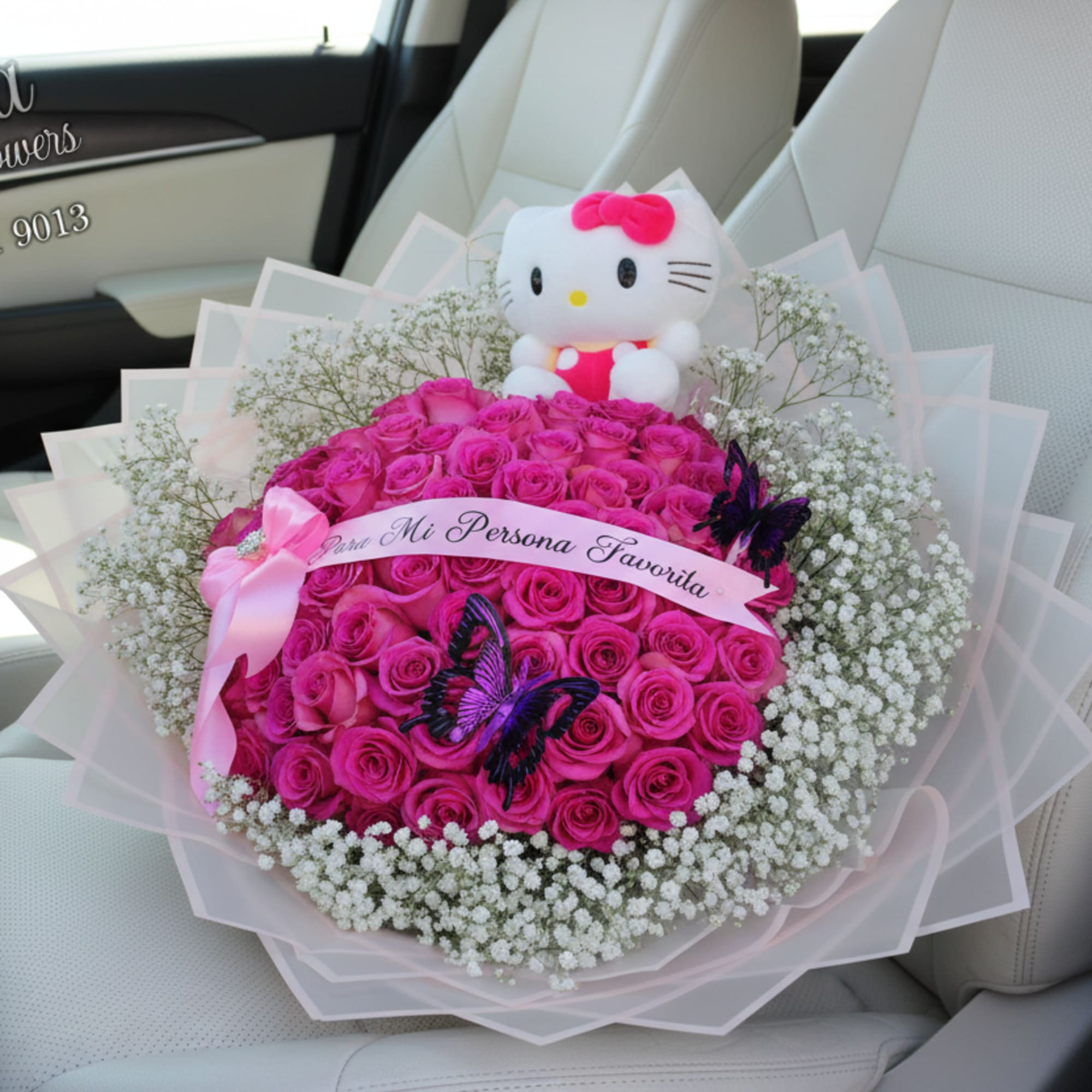 Large bouquet of hot pink roses with white filler flowers, Hello Kitty plush, and butterflies wrapped in pink paper