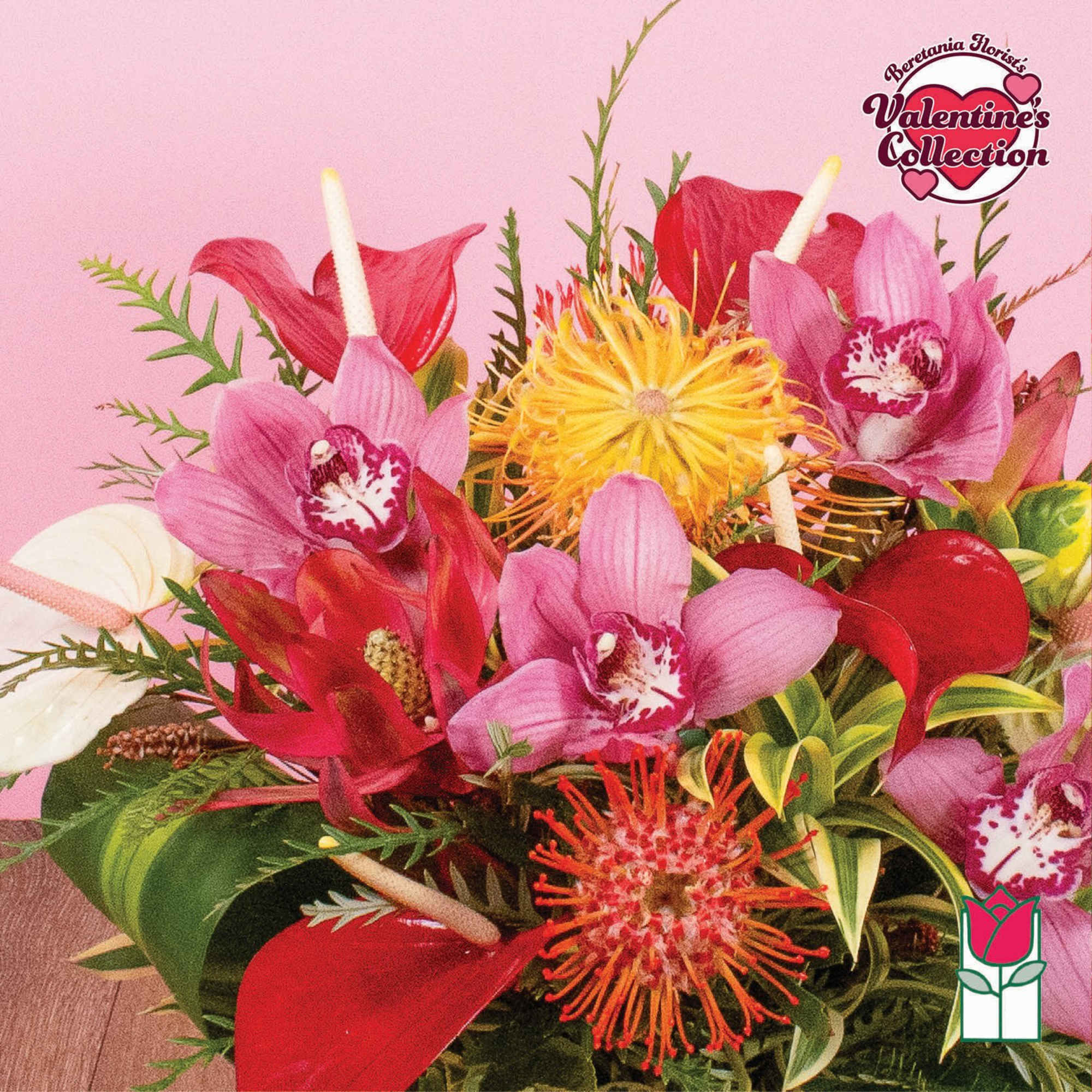 Tropical arrangement with pink orchids, red anthuriums, and yellow pincushion protea on a pink background