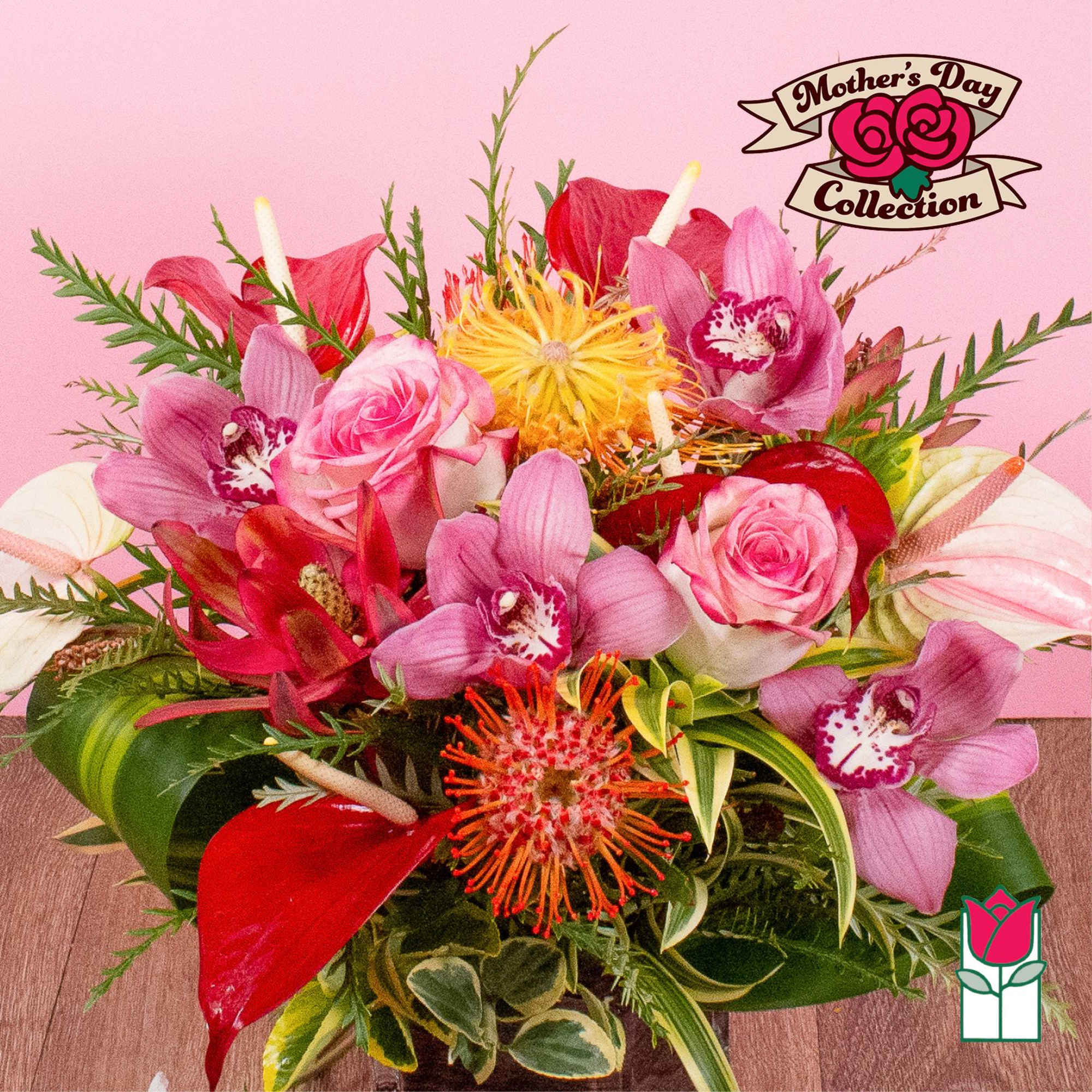 Colorful arrangement of pink roses, orchids, and tropical blooms in a low mixed bouquet
