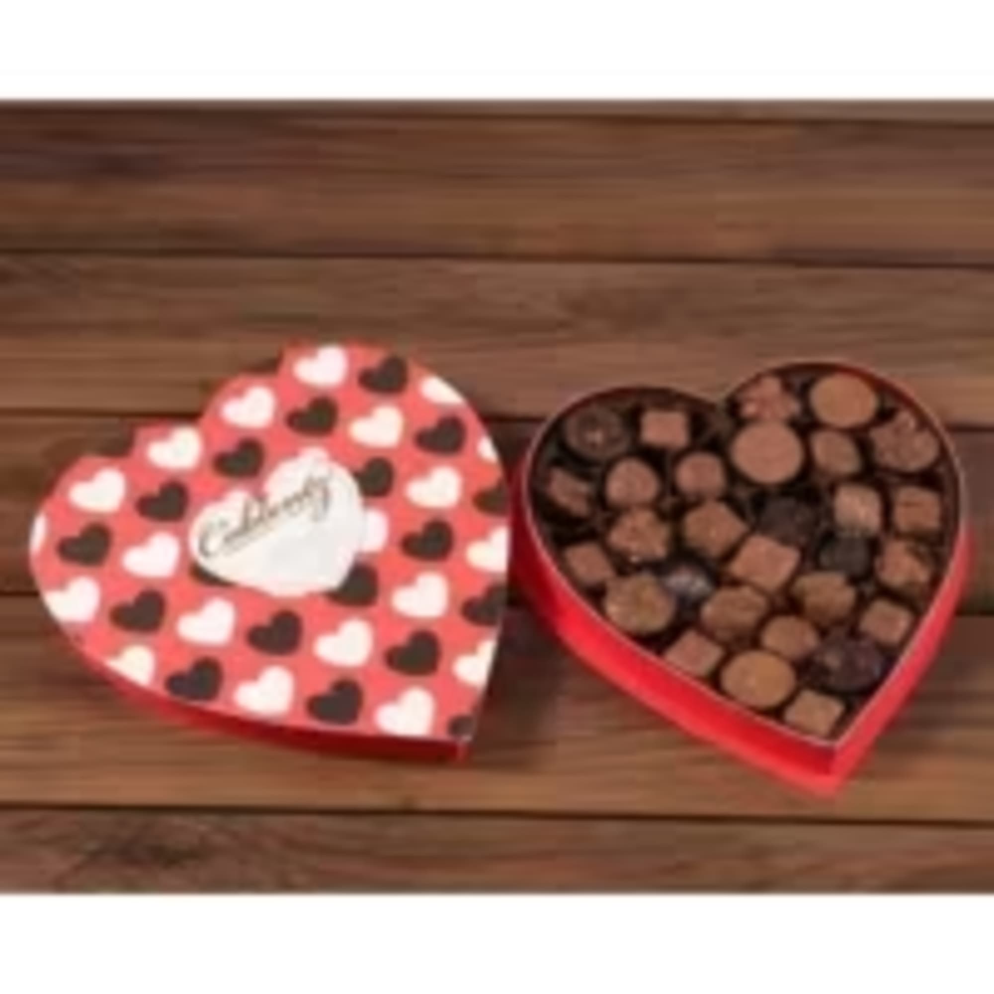 Heart-shaped box of assorted chocolates with a red heart-patterned lid on a wooden surface