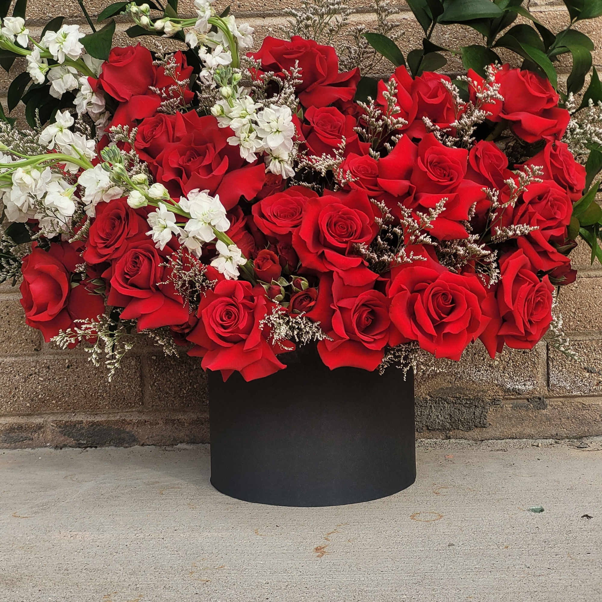 A bold and romantic arrangement of rich red roses accented with delicate