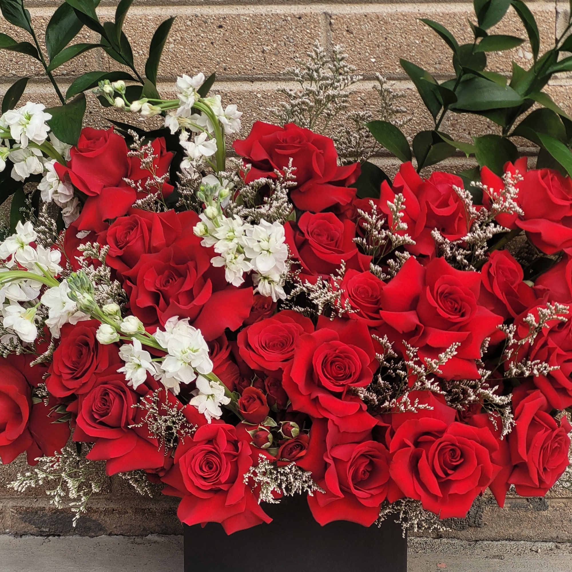 A bold and romantic arrangement of rich red roses accented with delicate