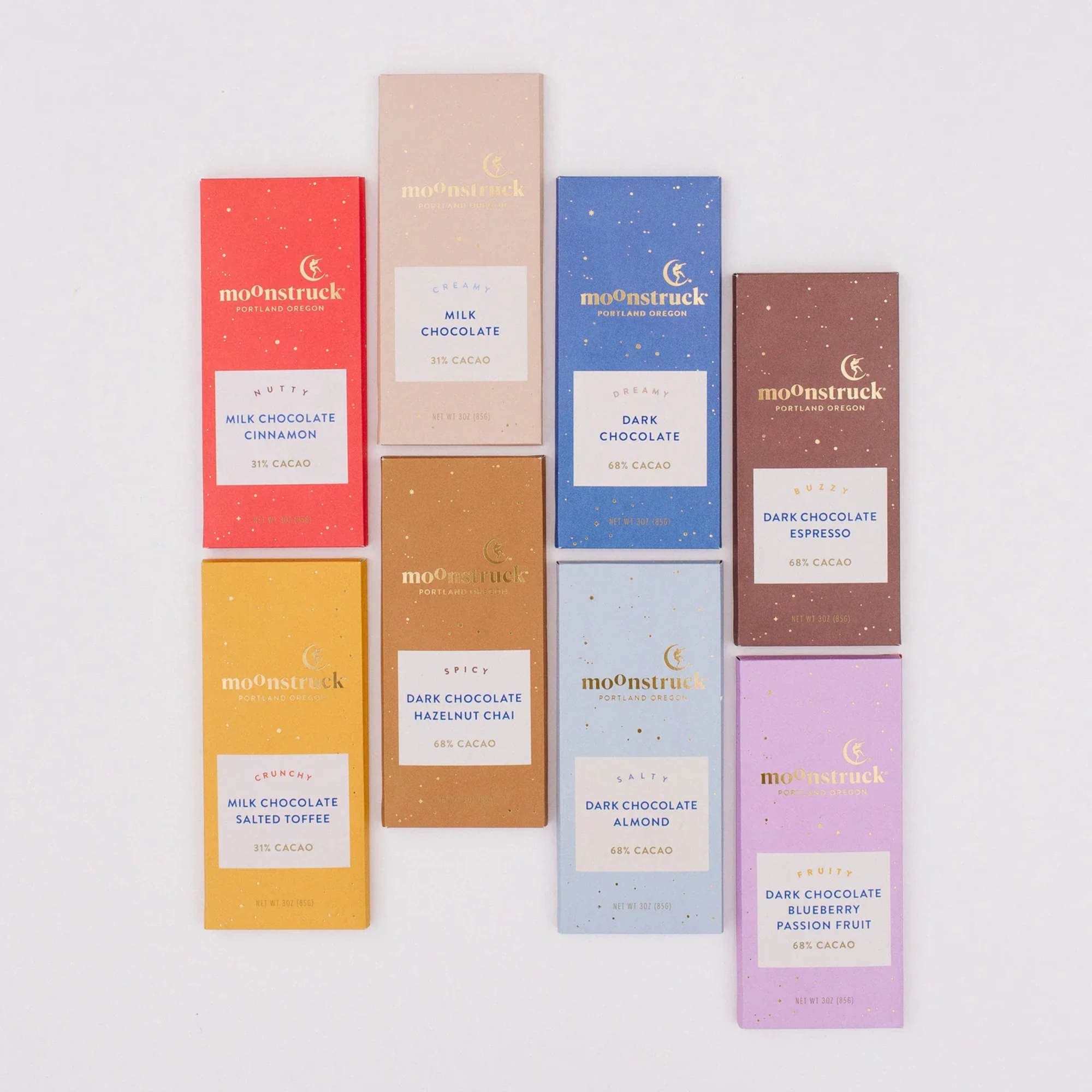 Assorted colorful Moonstruck chocolate bars arranged in a grid on a white background