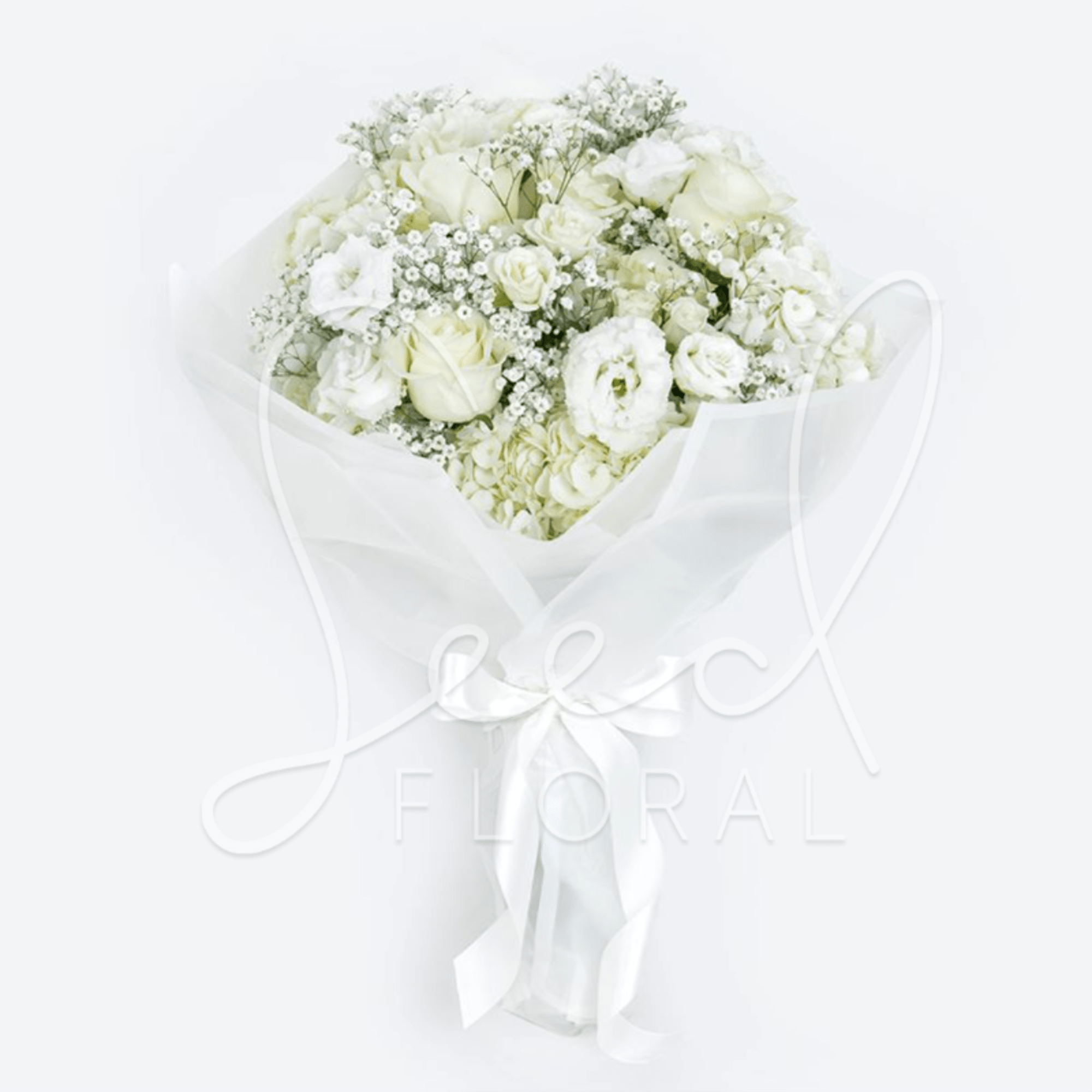 Monochromatic white bouquet of roses, lisianthus, and hydrangea wrapped in white paper with a satin bow.