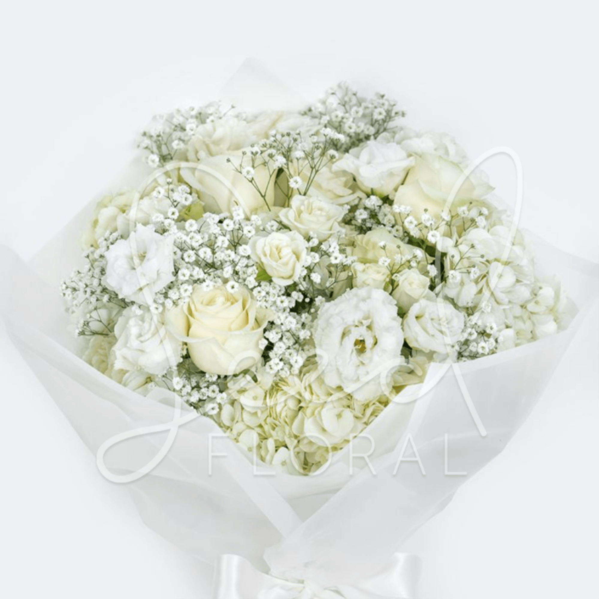 All-white bouquet of roses, lisianthus, and small filler blooms wrapped in white paper with a satin ribbon.
