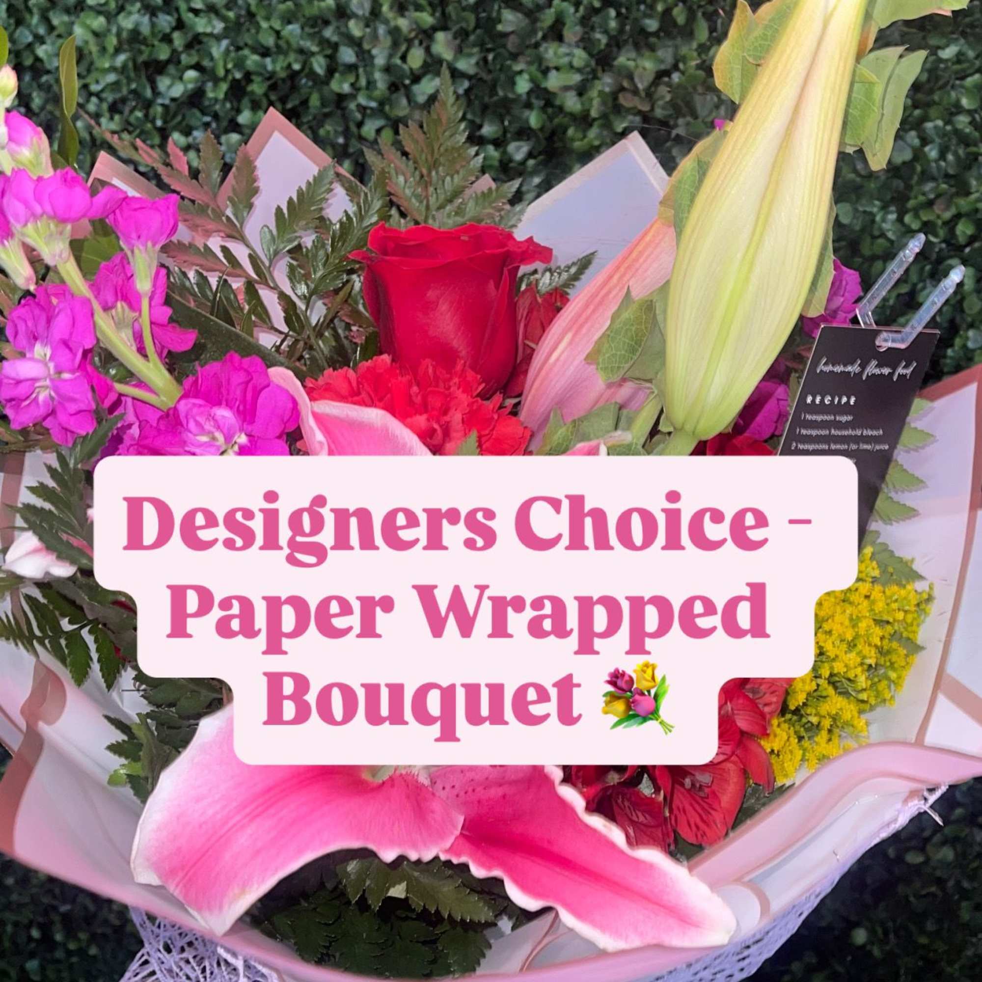 Paper-wrapped bouquet with pink and red flowers and a red rose