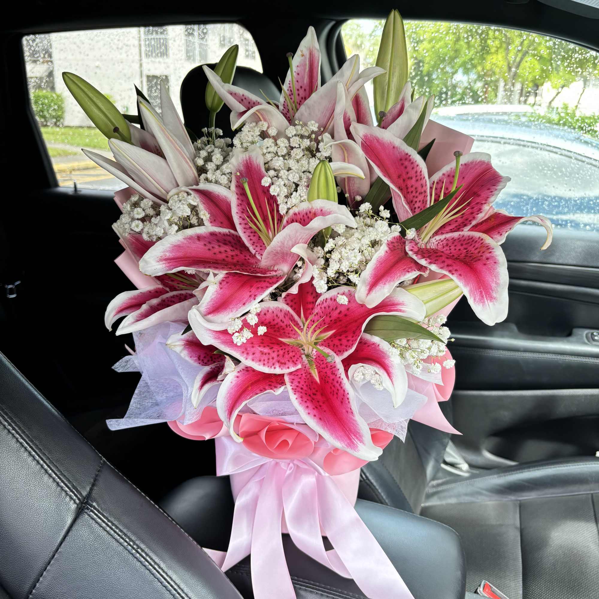 Bouquet of pink stargazer lilies with white filler and pink wrapping