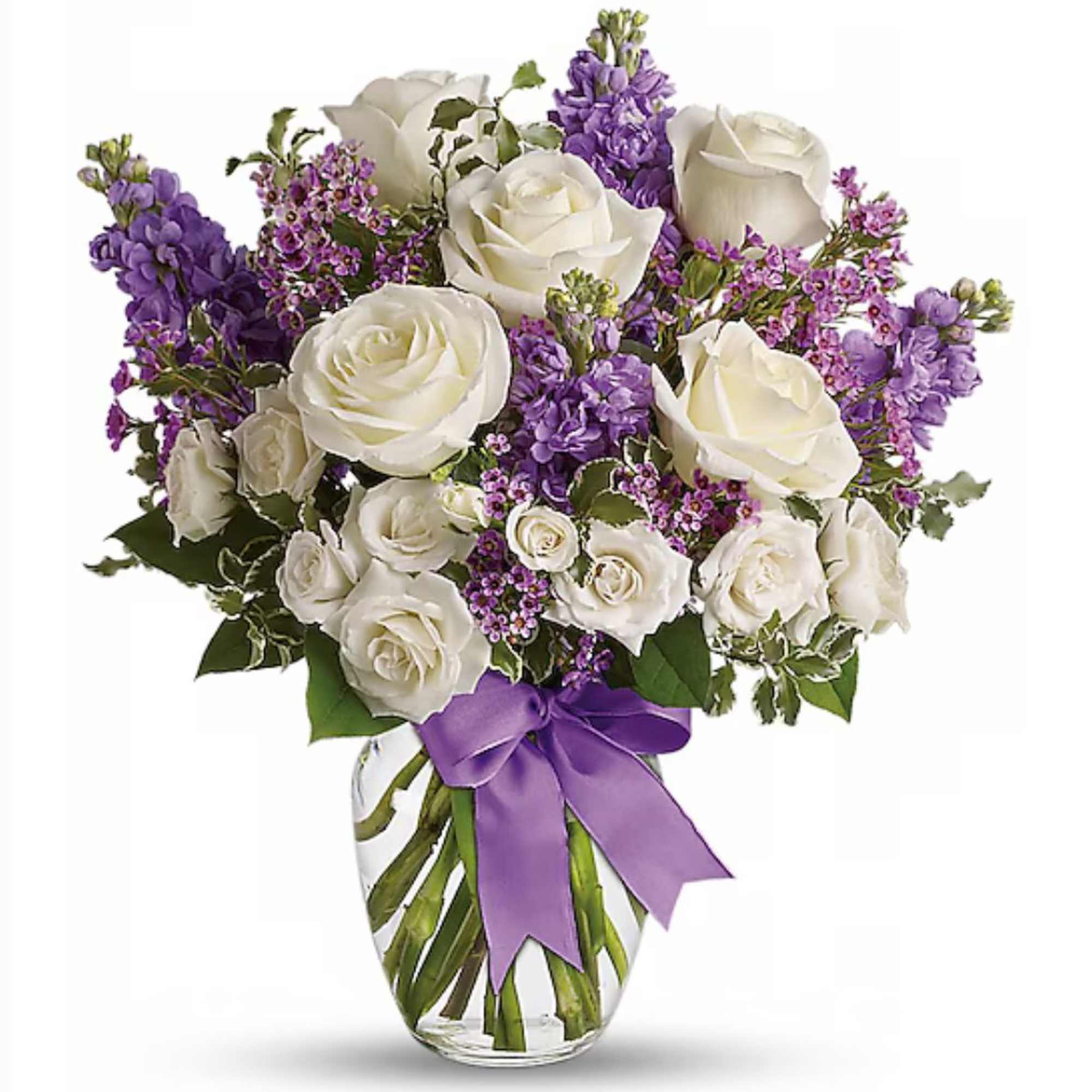 White rose and purple flower arrangement in a clear vase with a purple ribbon bow