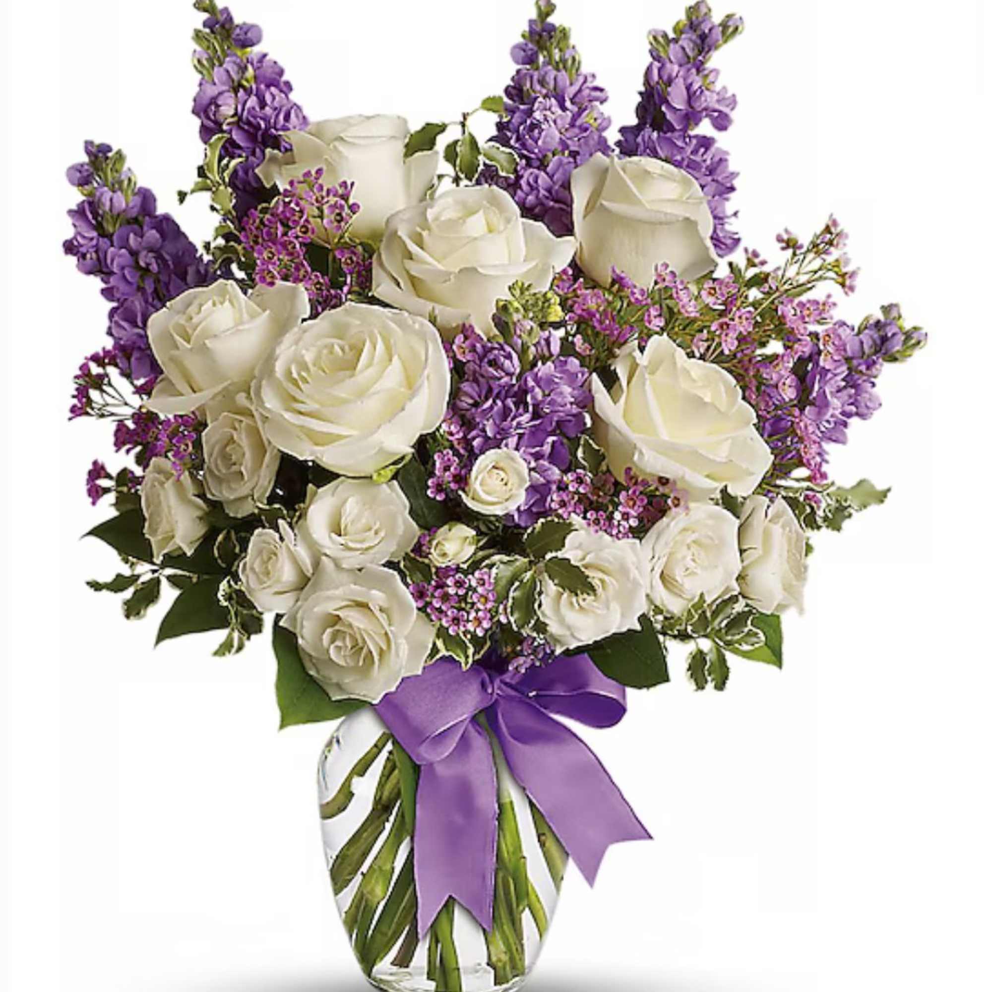 White rose and purple flower arrangement in a clear glass vase with a purple ribbon