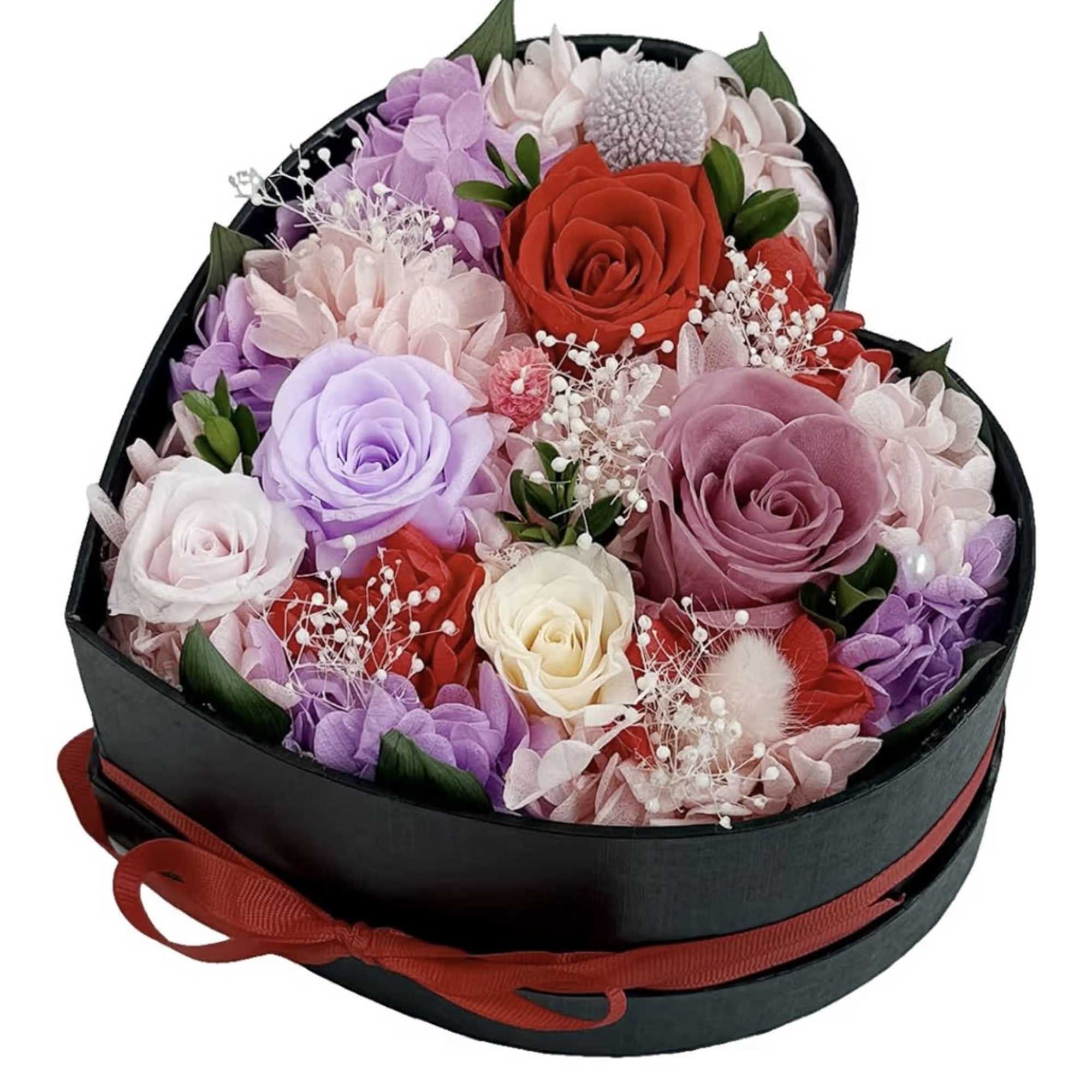 Heart-shaped black box filled with red, pink, lavender and cream roses and small filler flowers
